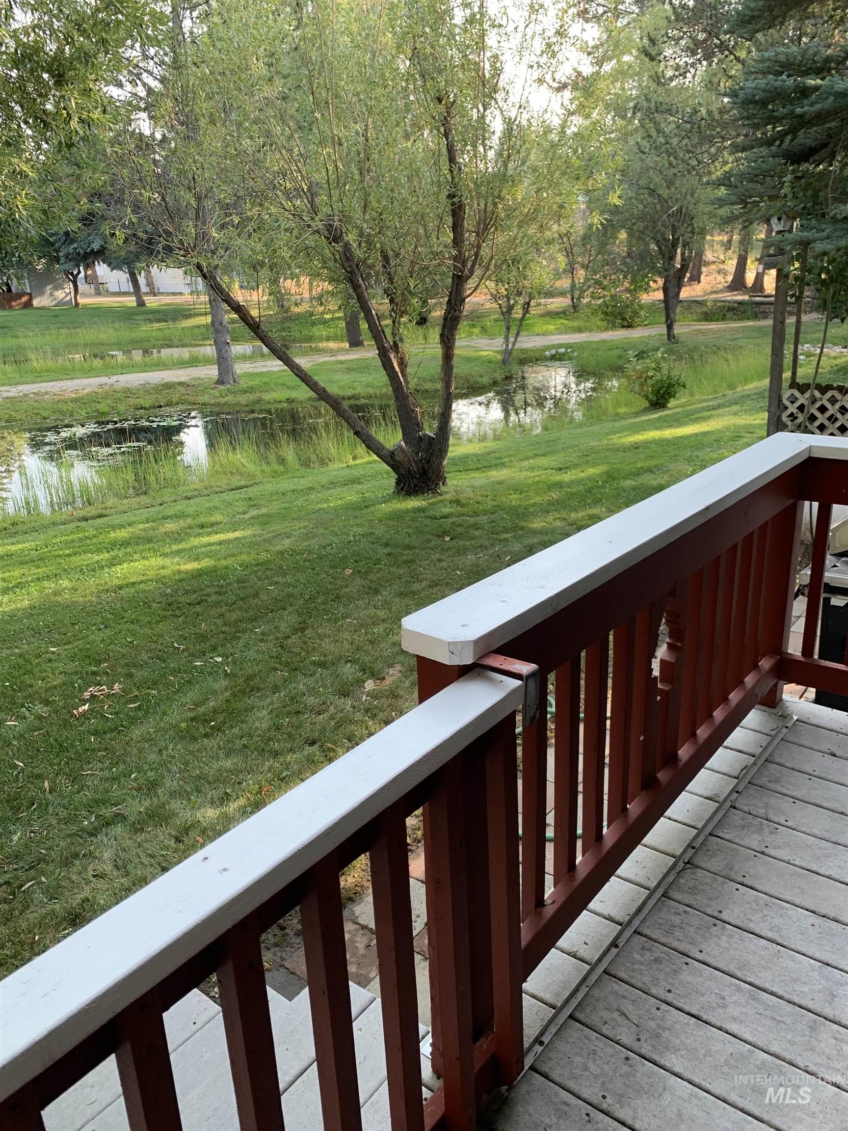 Wooden deck featuring a water view and a yard