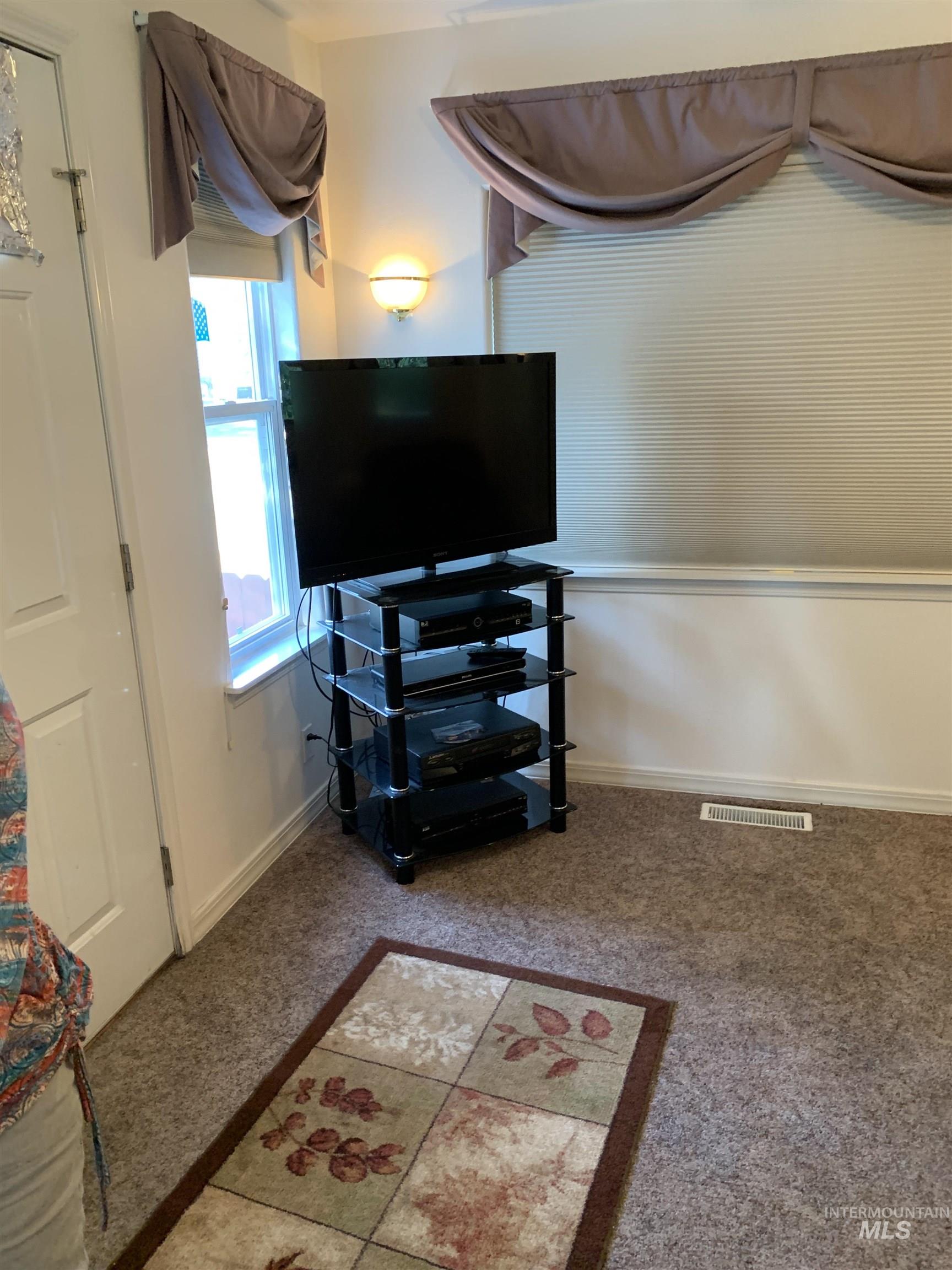 Bedroom featuring light carpet and baseboards