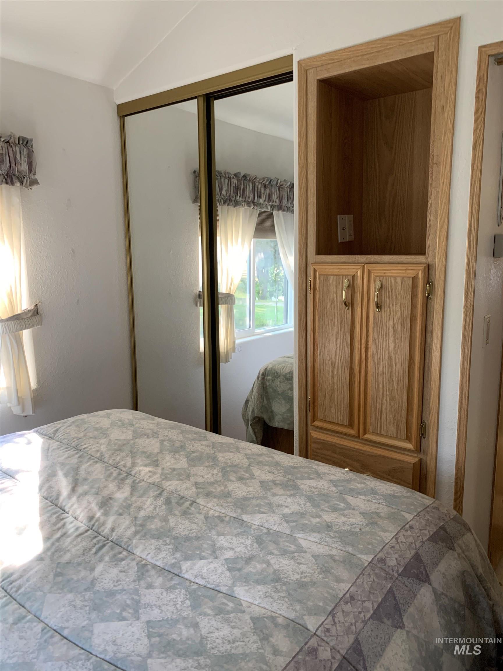 Bedroom with a closet and vaulted ceiling