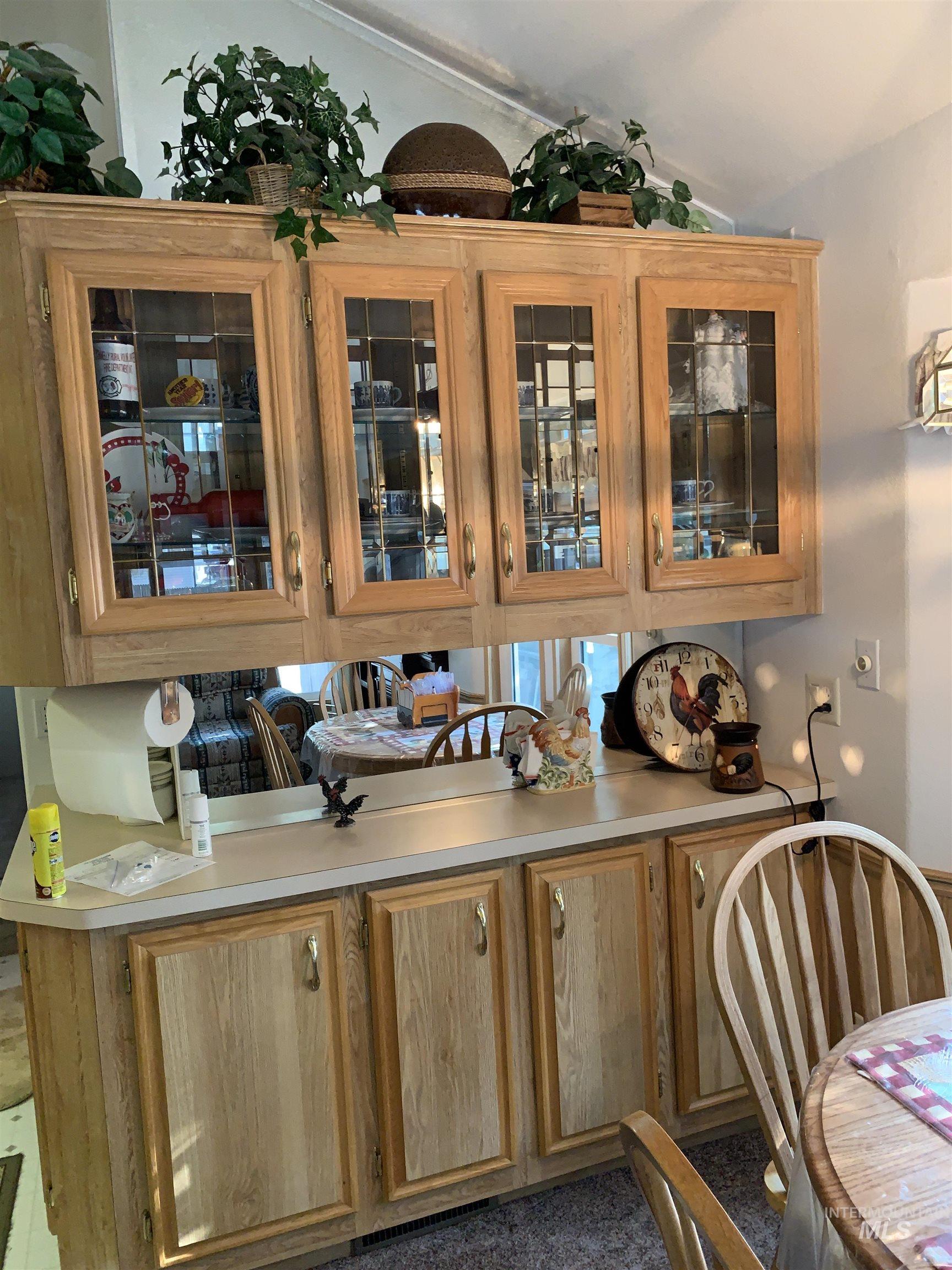 Bar area featuring glass insert cabinets and light countertops