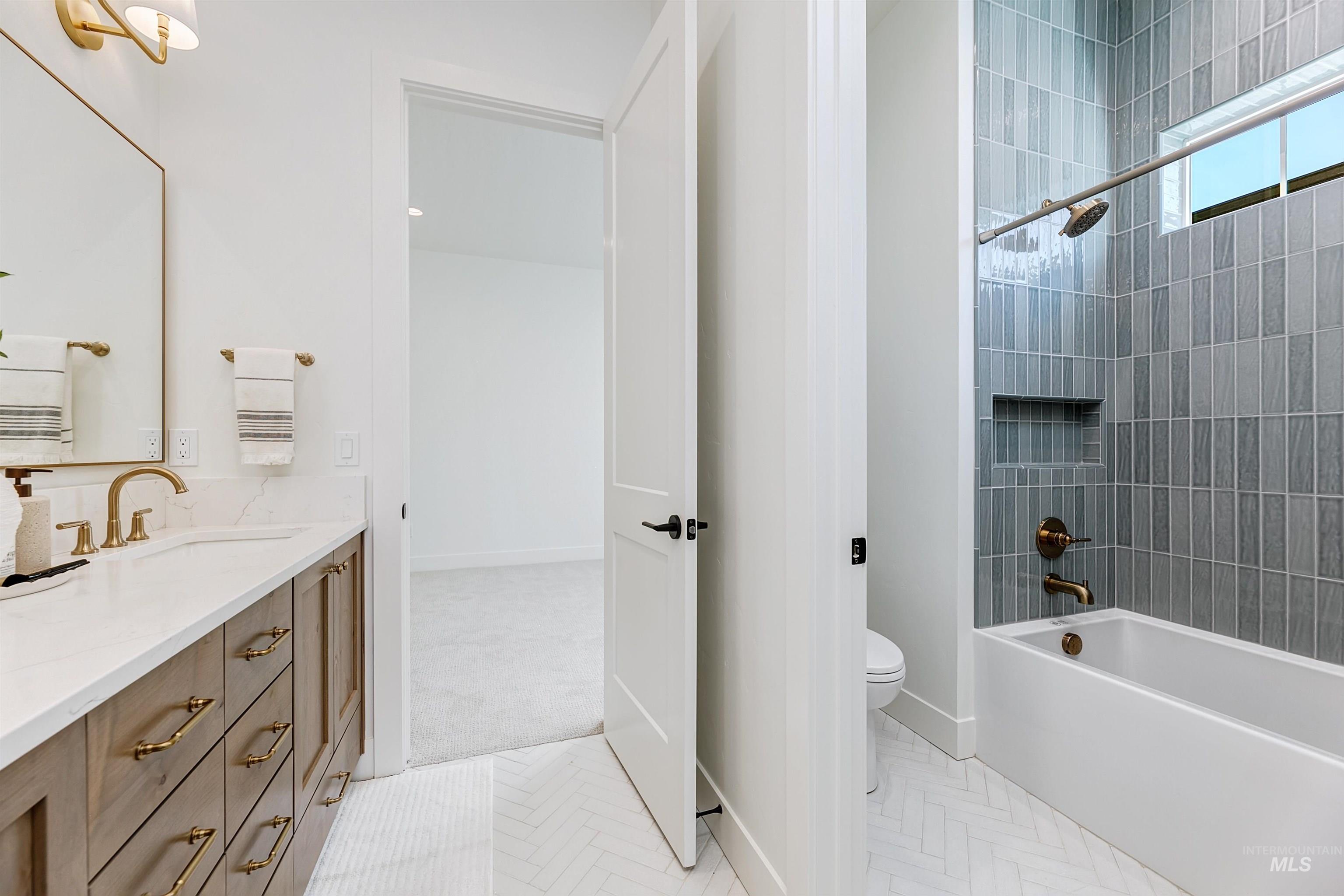 Bathroom featuring vanity, washtub / shower combination, and light tile patterned floors