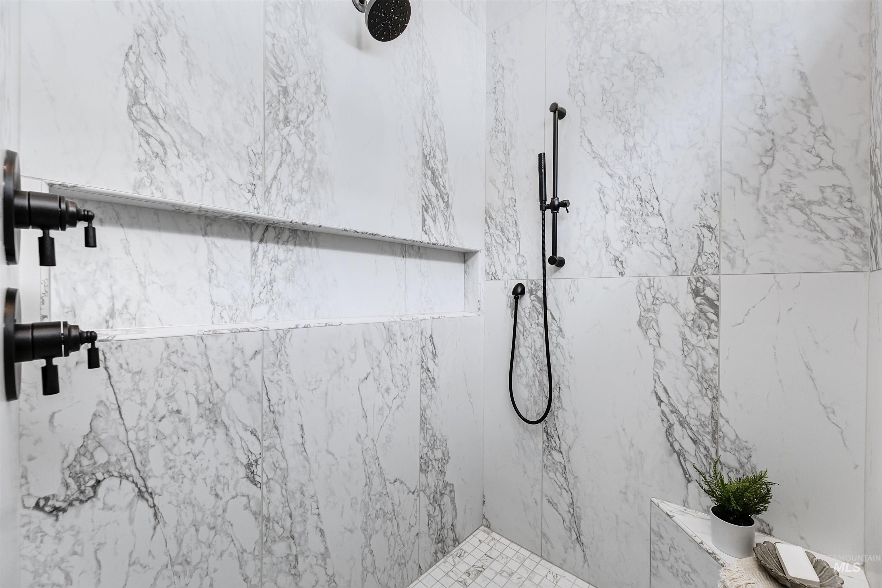Full bathroom with a marble finish shower