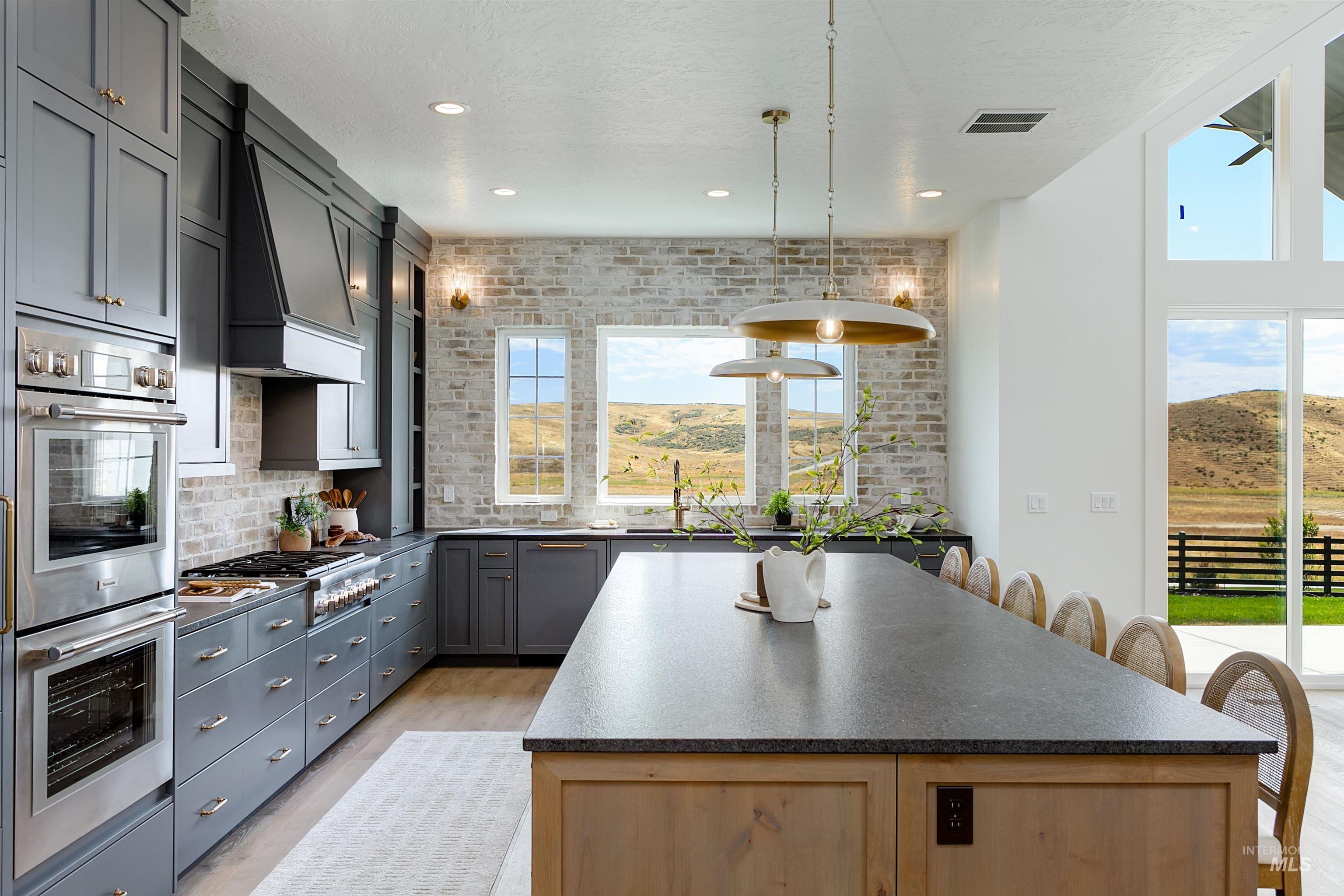 Kitchen featuring appliances with stainless steel finishes, a breakfast bar, a center island, decorative light fixtures, and tasteful backsplash