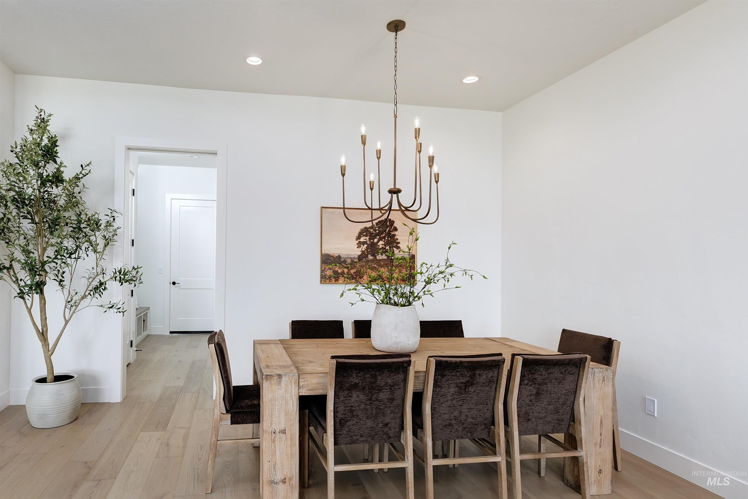 Dining area featuring light wood-type flooring, a chandelier, and recessed lighting