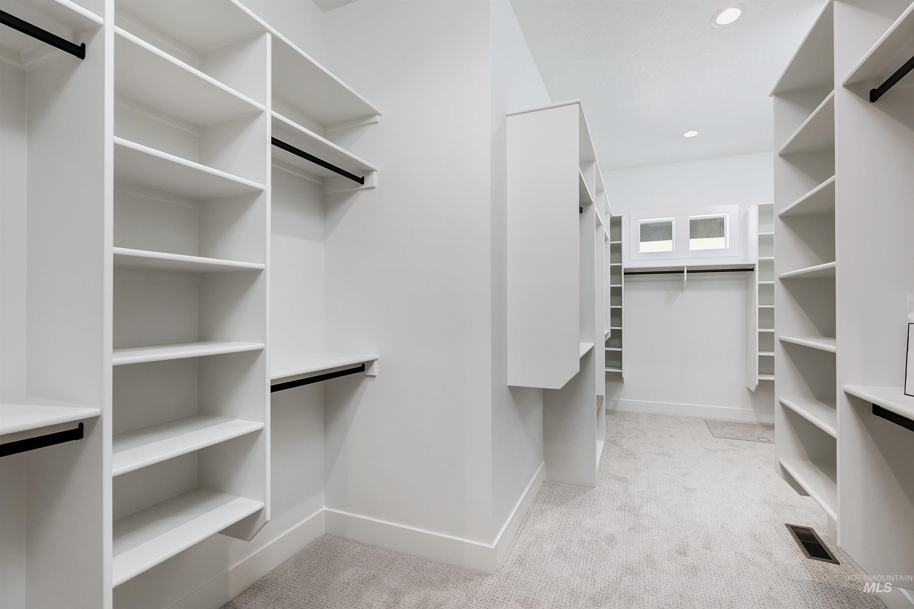 Spacious closet with light colored carpet