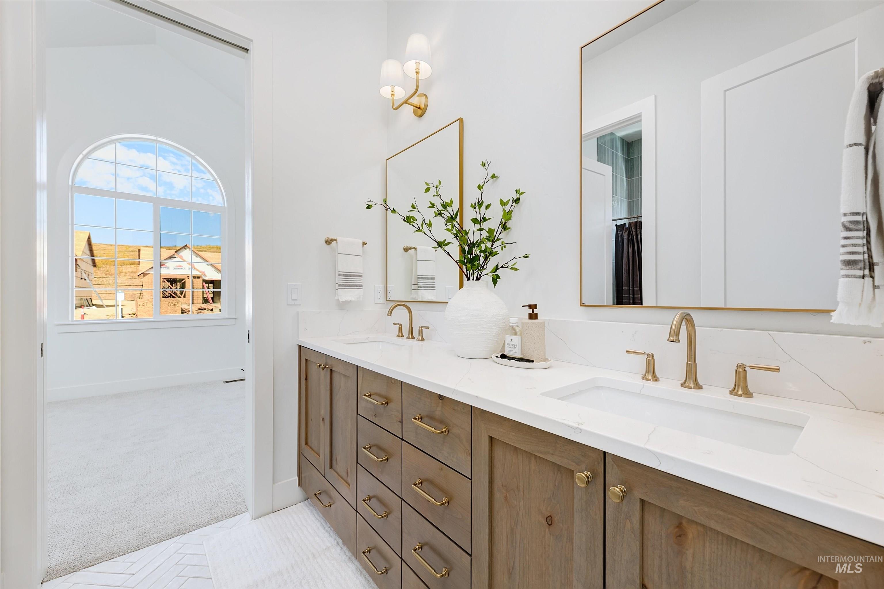 Full bath featuring double vanity and light tile patterned floors