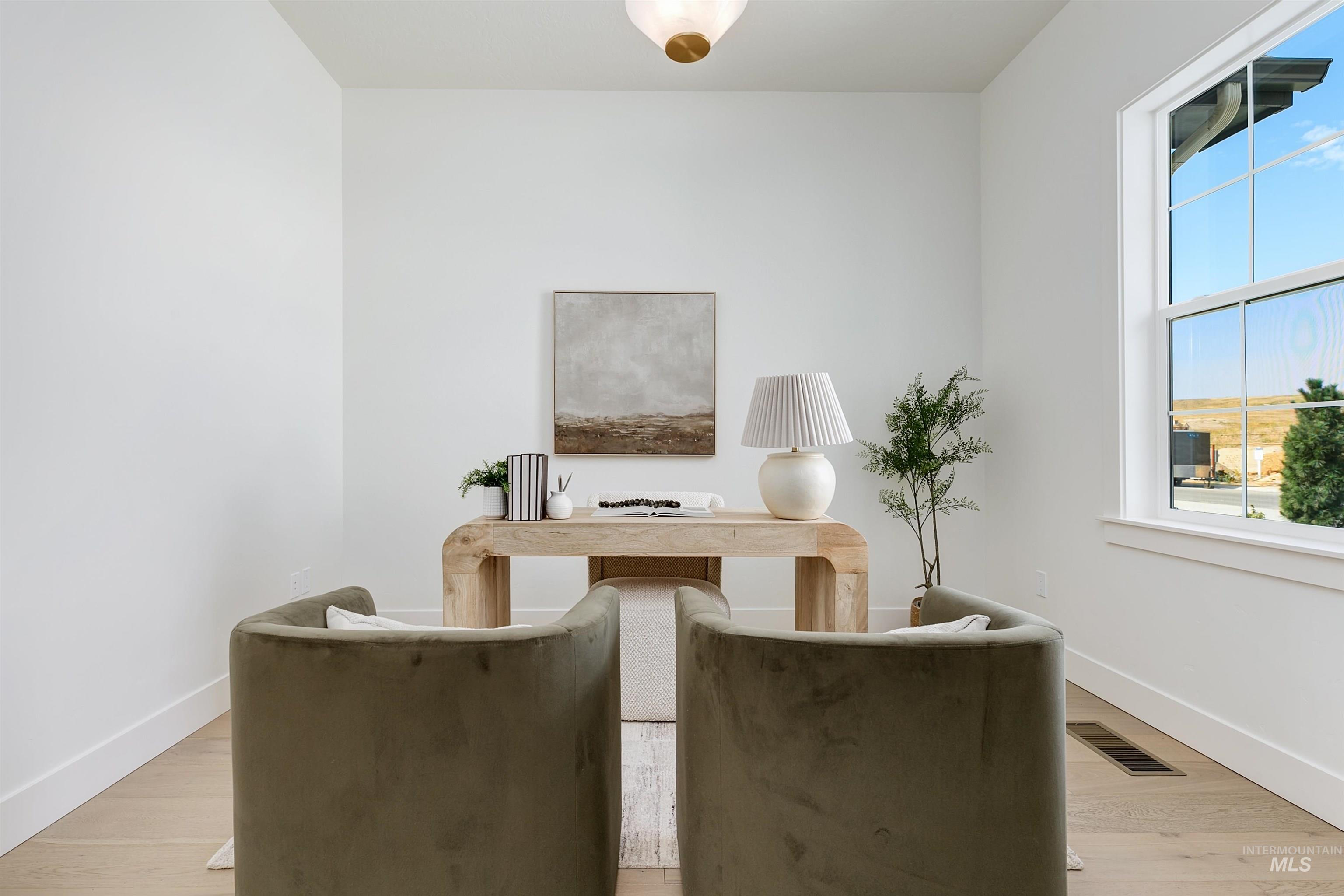 Living area featuring light wood-style flooring and a desk