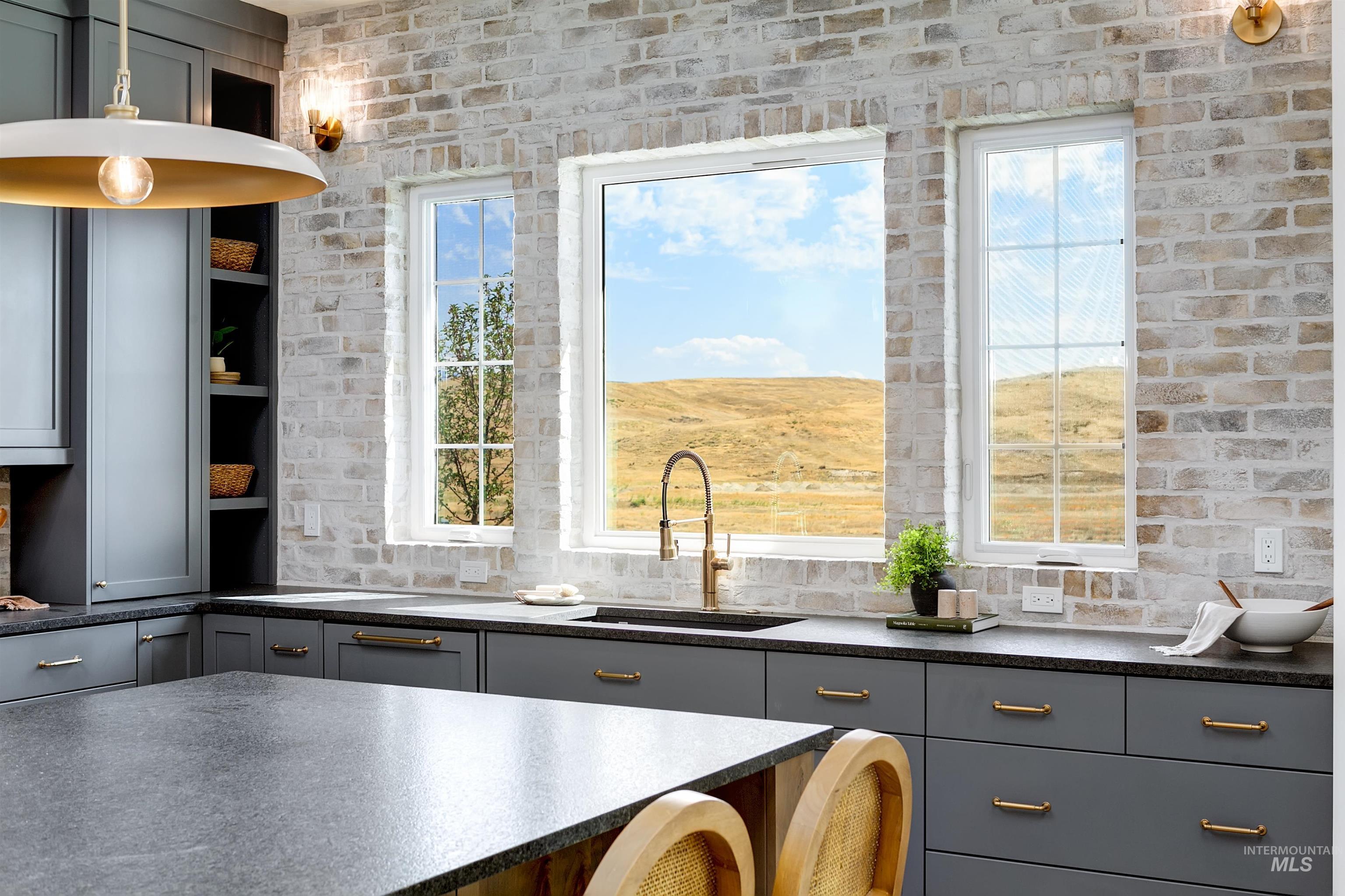 Kitchen featuring gray cabinets, healthy amount of natural light, open shelves, and dark stone countertops