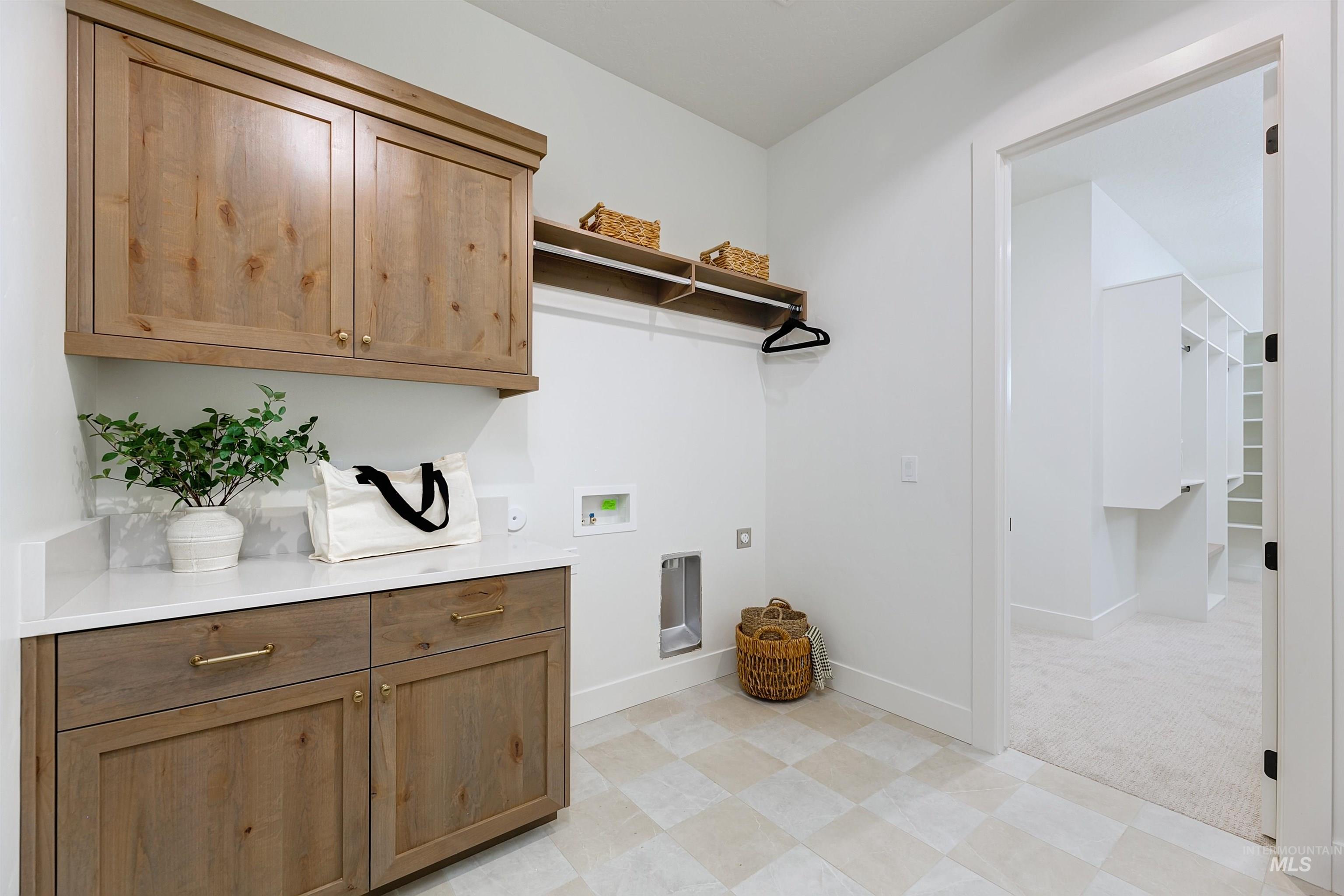 Laundry room with hookup for a washing machine, cabinet space, and hookup for an electric dryer