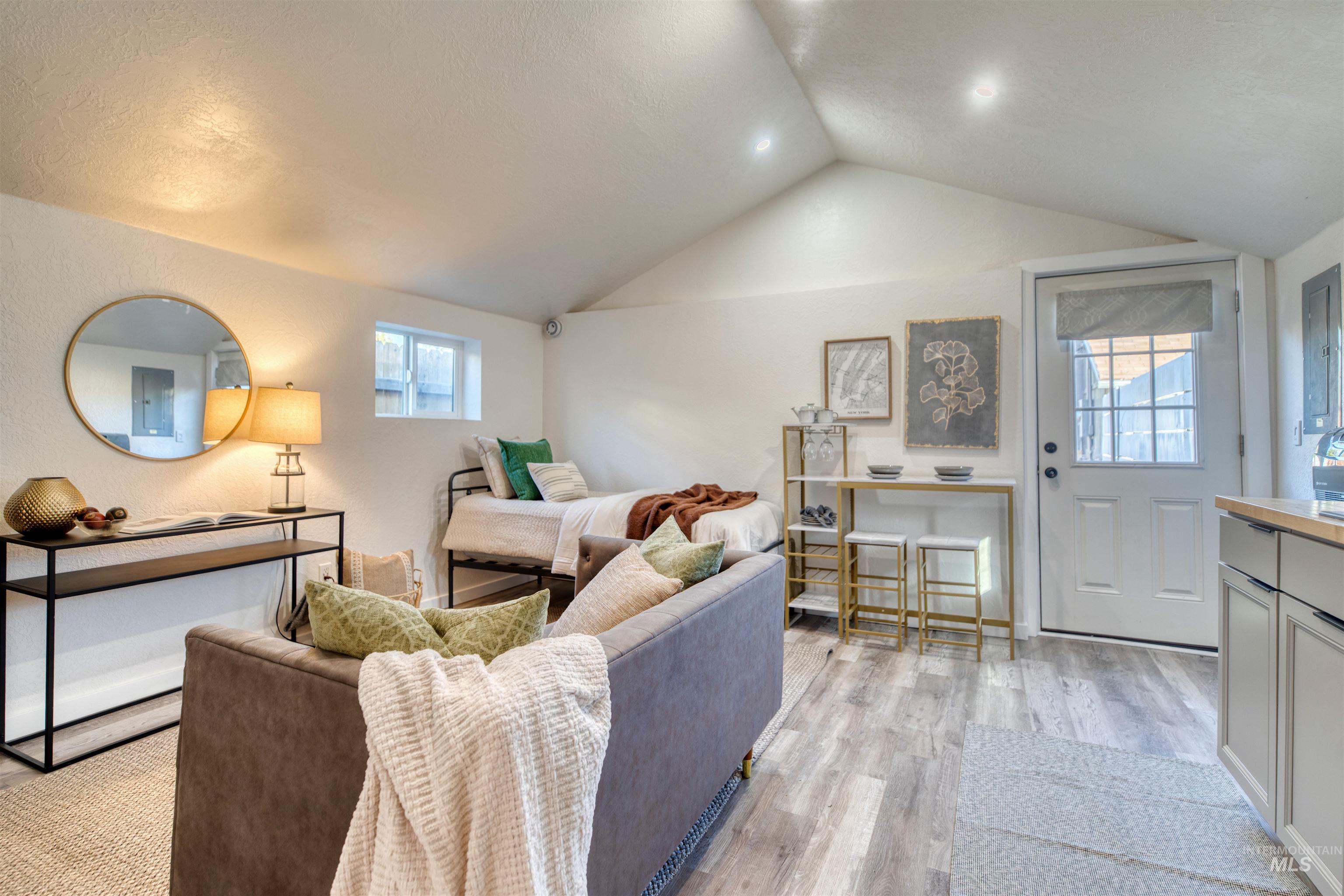 Living room with lofted ceiling and light wood-style floors