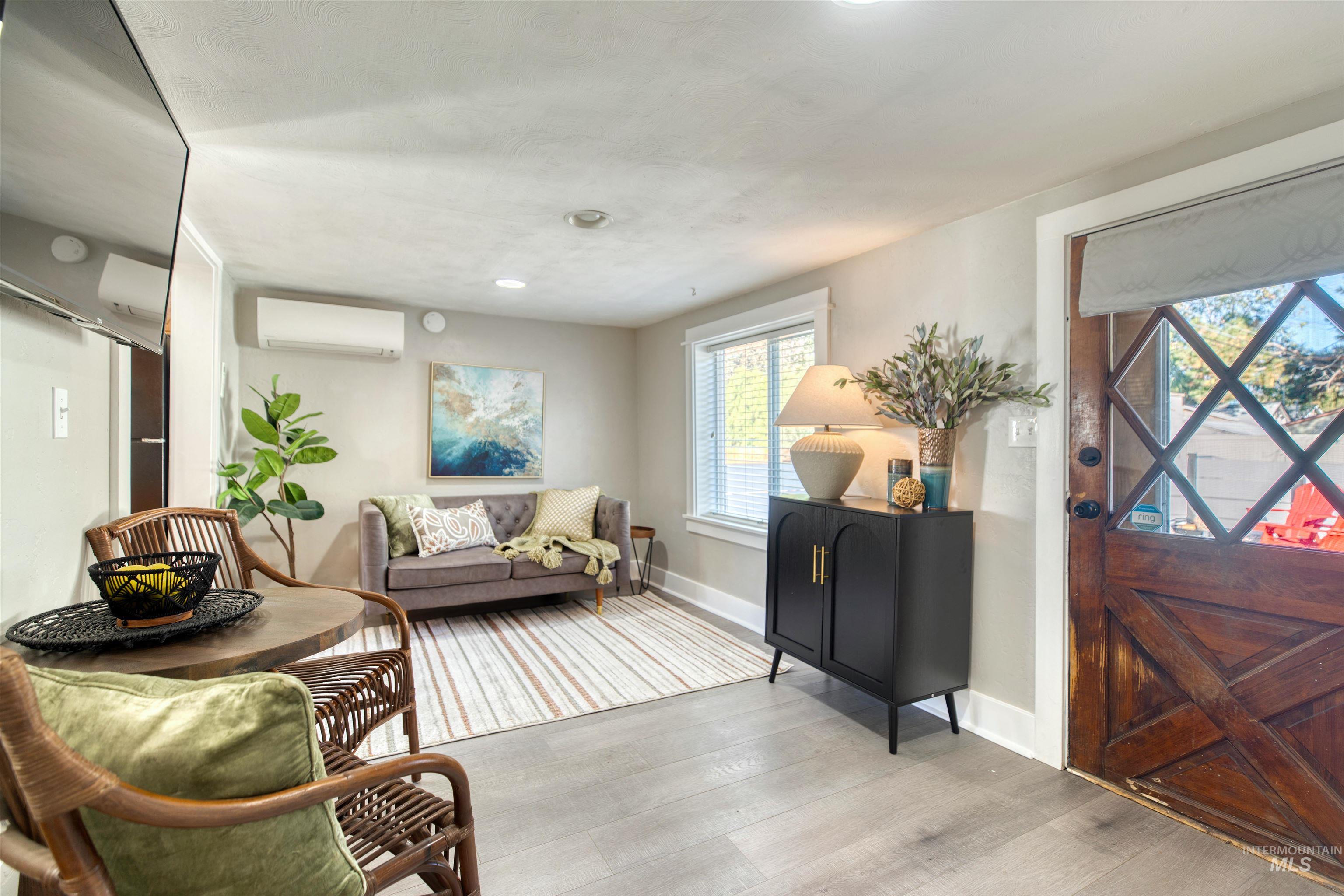 Foyer entrance with wood finished floors and a wall mounted AC