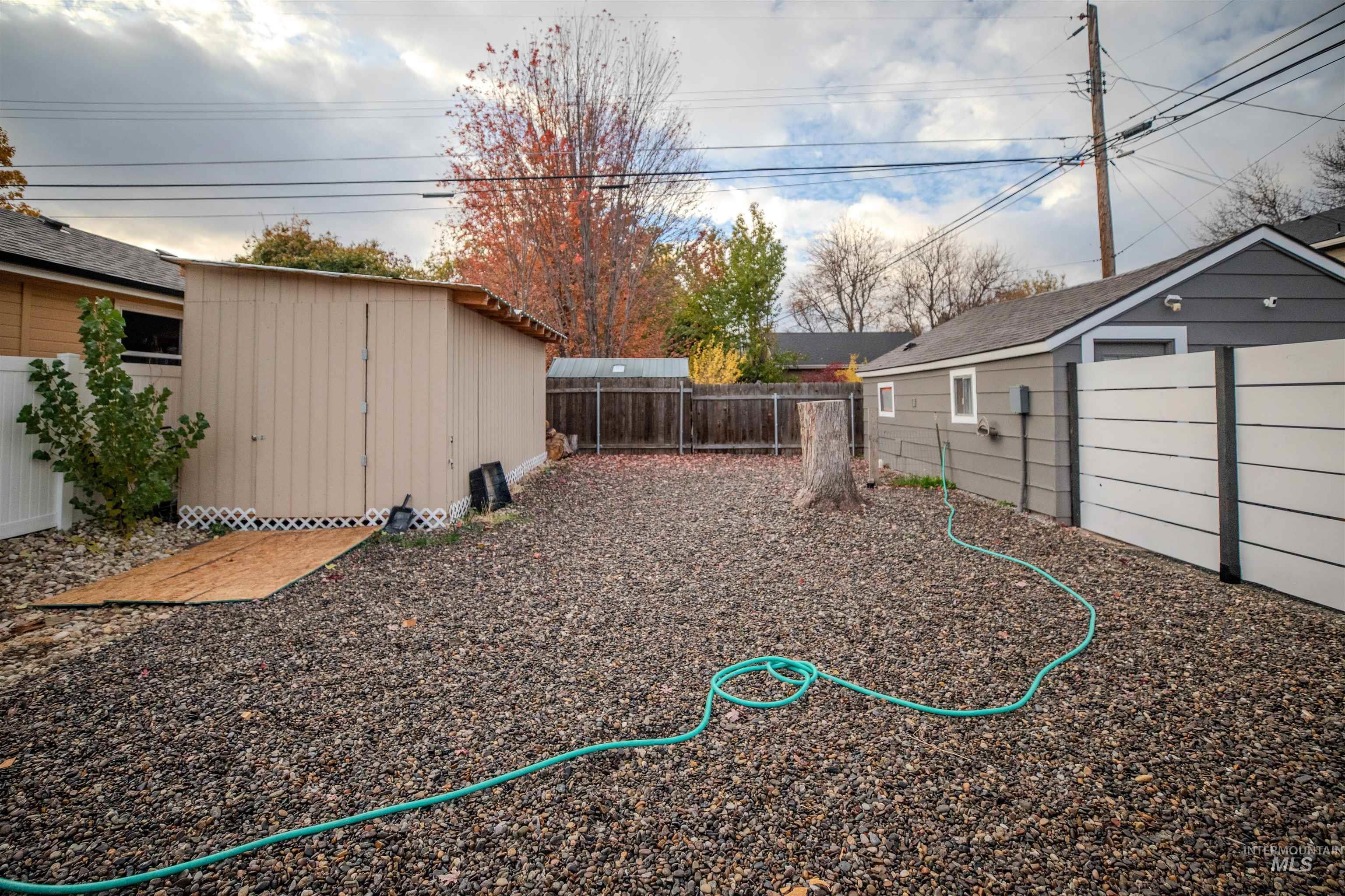 Fenced backyard with a storage shed.