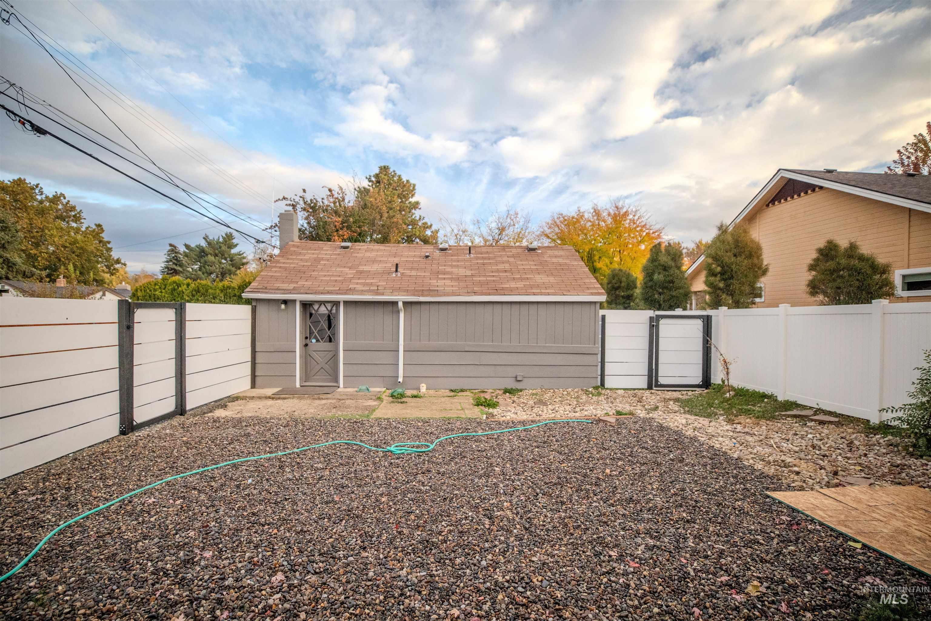 Fenced backyard featuring a gate and storage shed