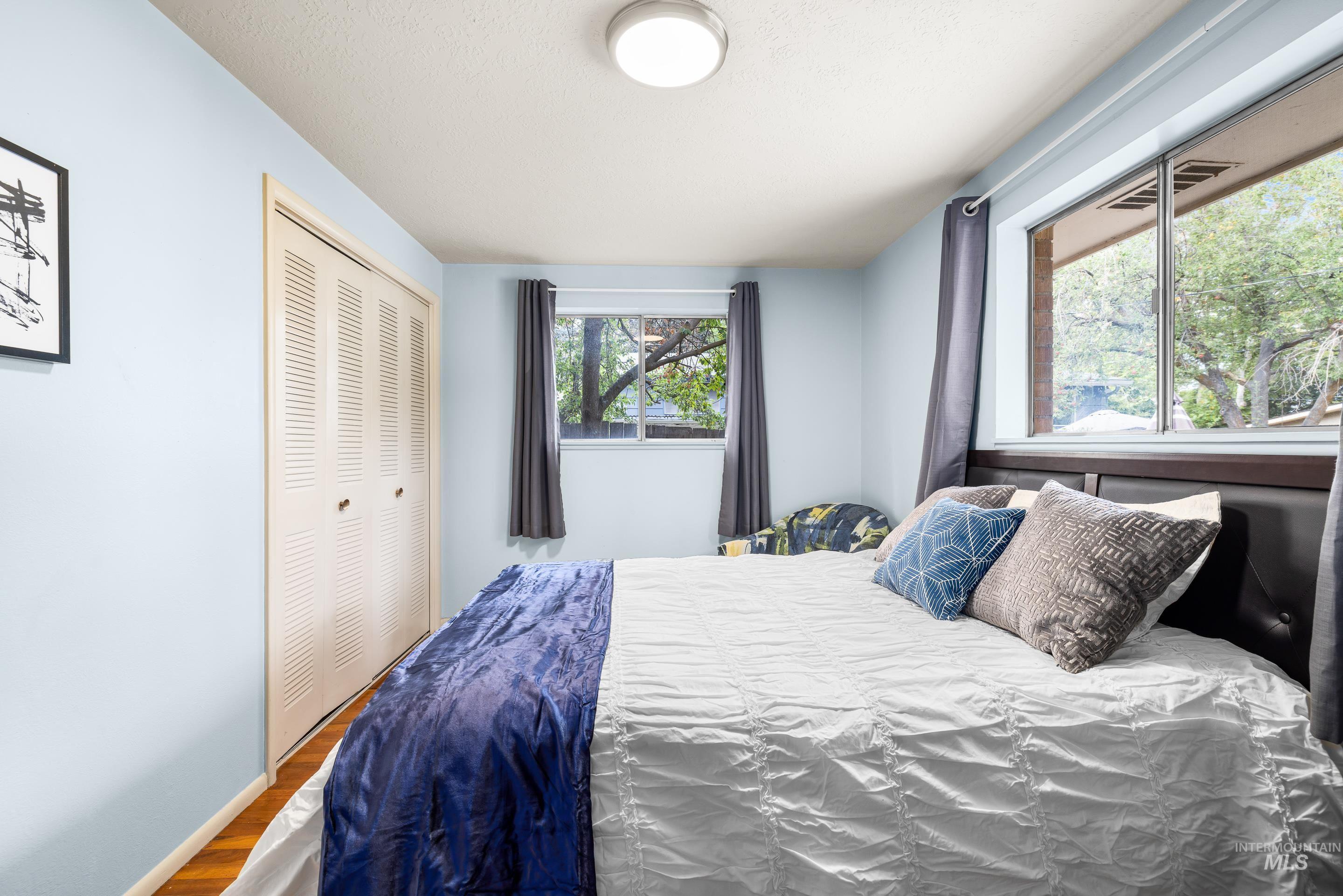 Bedroom with wood finished floors and a closet