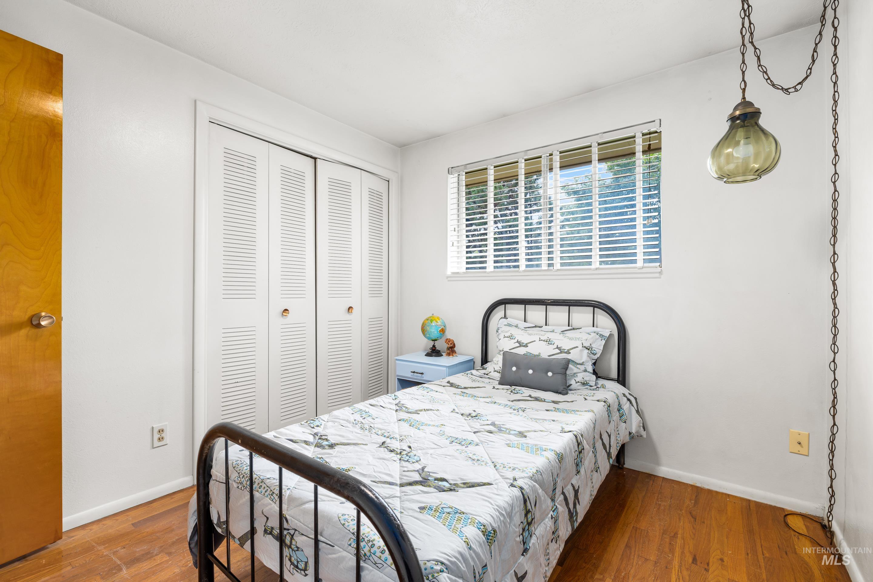Bedroom featuring wood finished floors and a closet