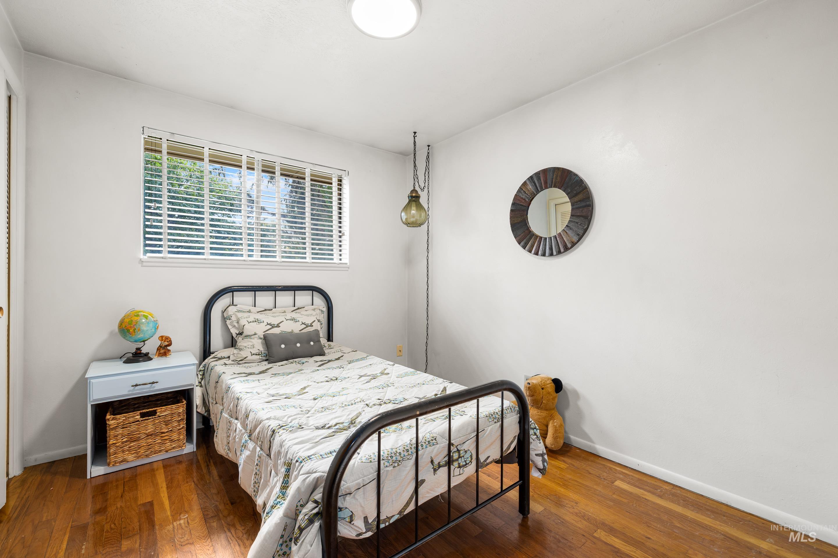 Bedroom with dark wood-style floors and baseboards