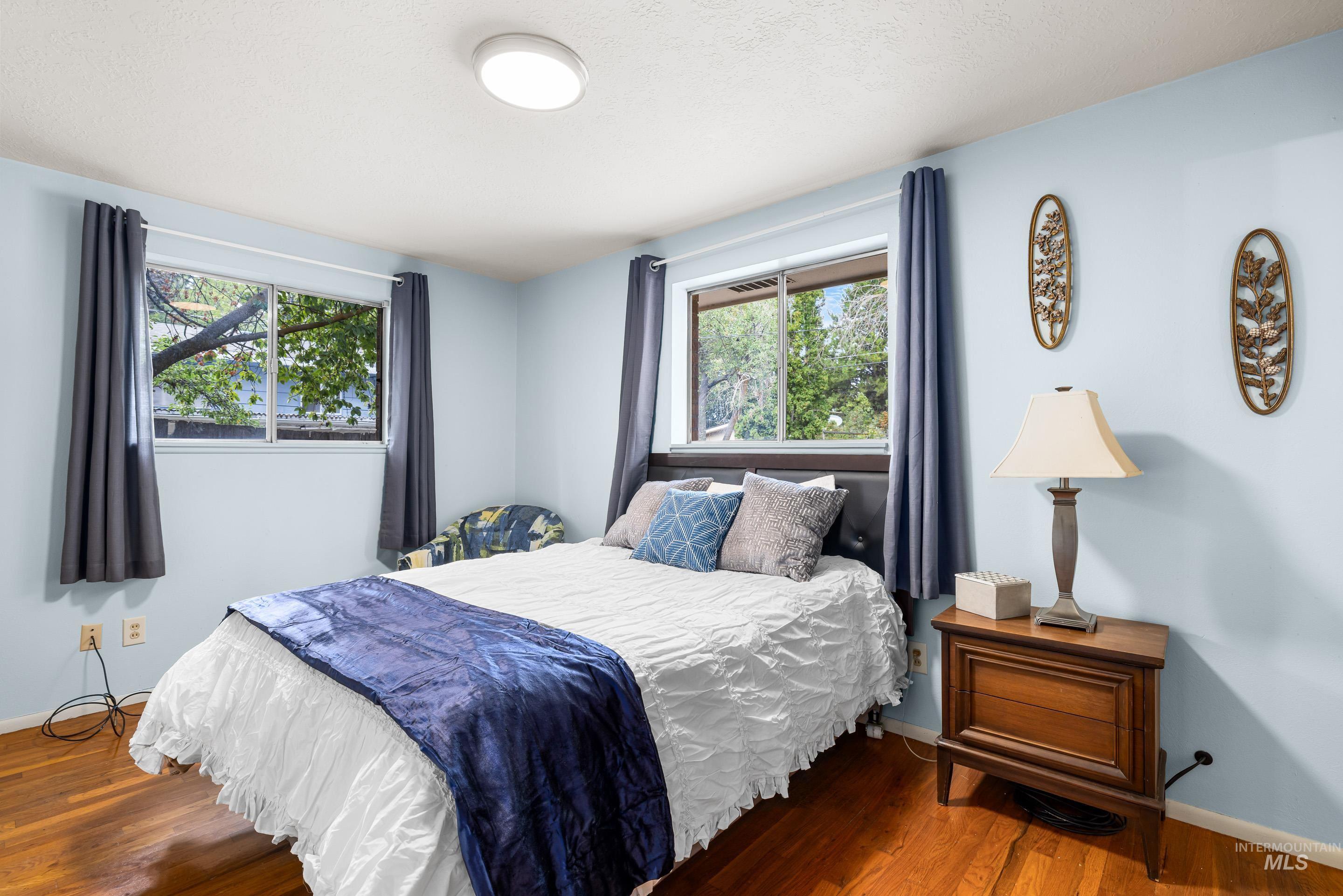 Bedroom with wood finished floors and baseboards