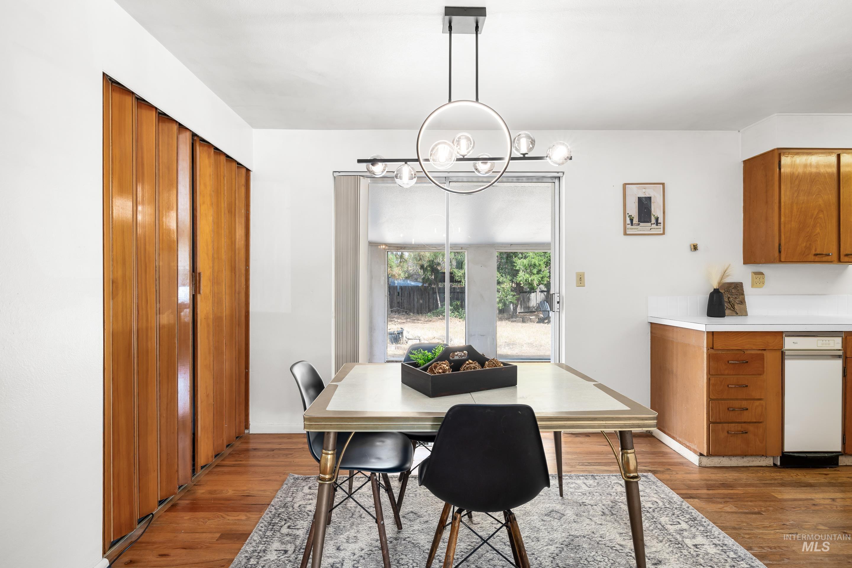 Dining room featuring dark wood-style floors and a chandelier