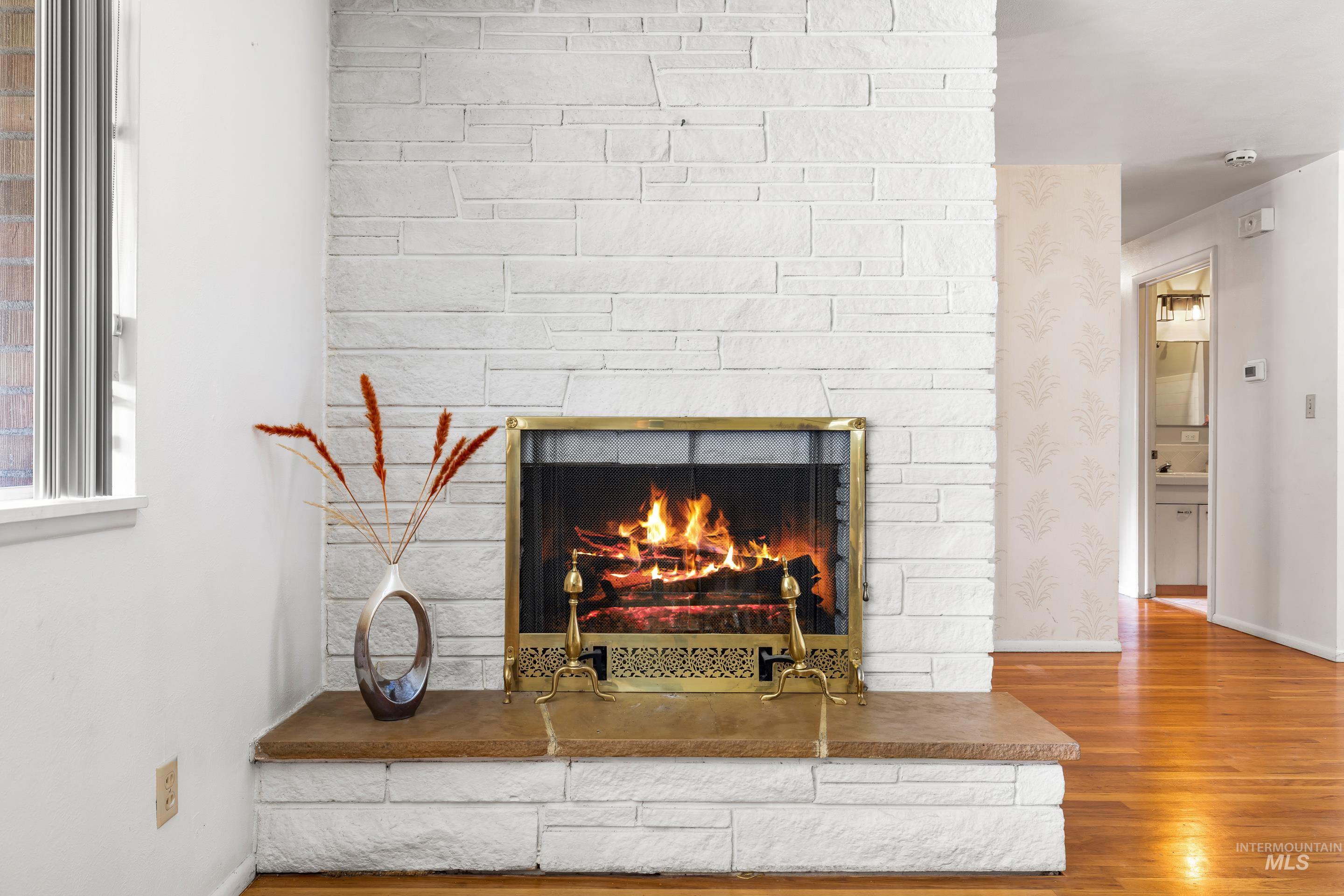 Detailed view of wood finished floors and a fireplace
