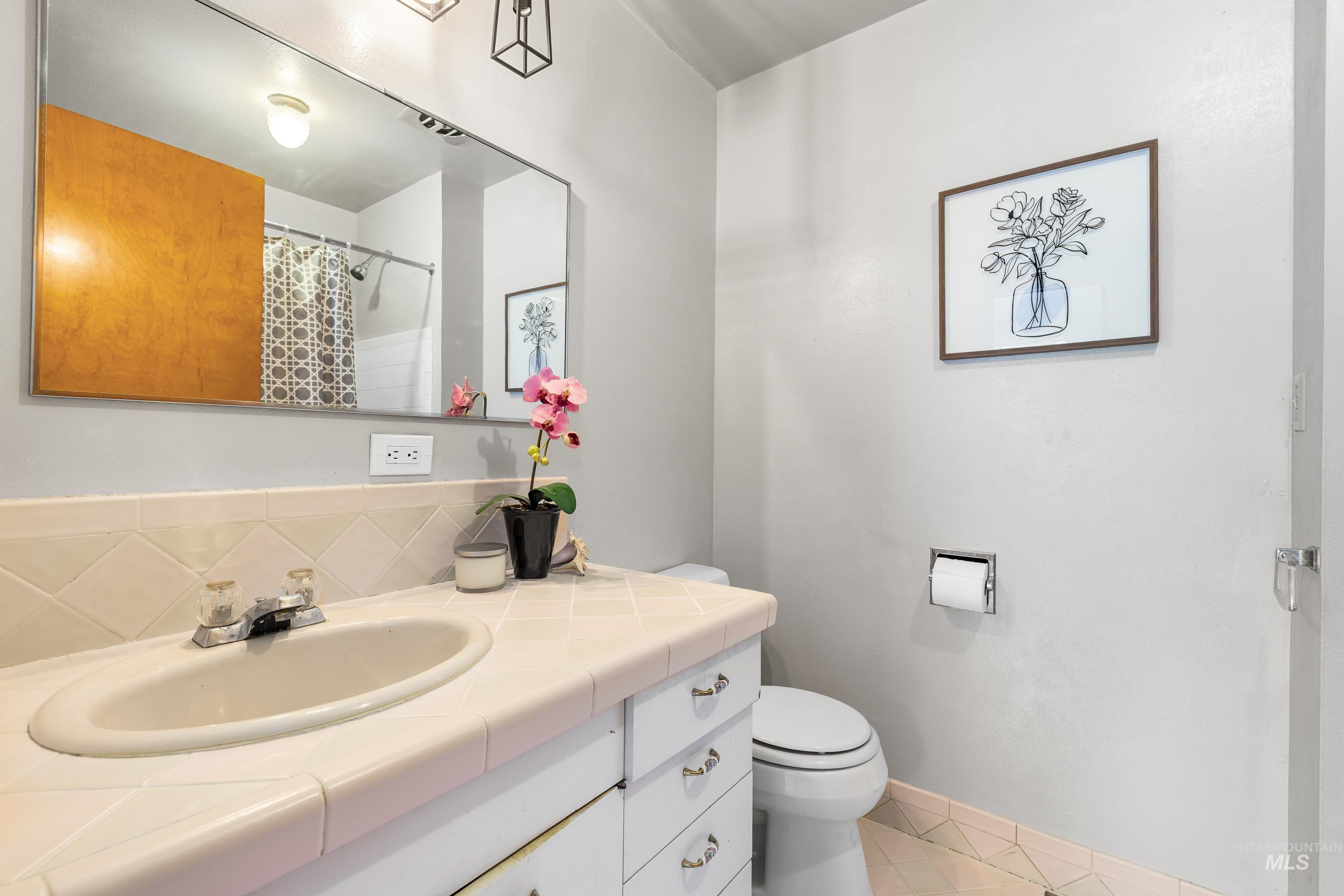 Full bathroom with vanity, light tile patterned flooring, a shower with shower curtain, and backsplash