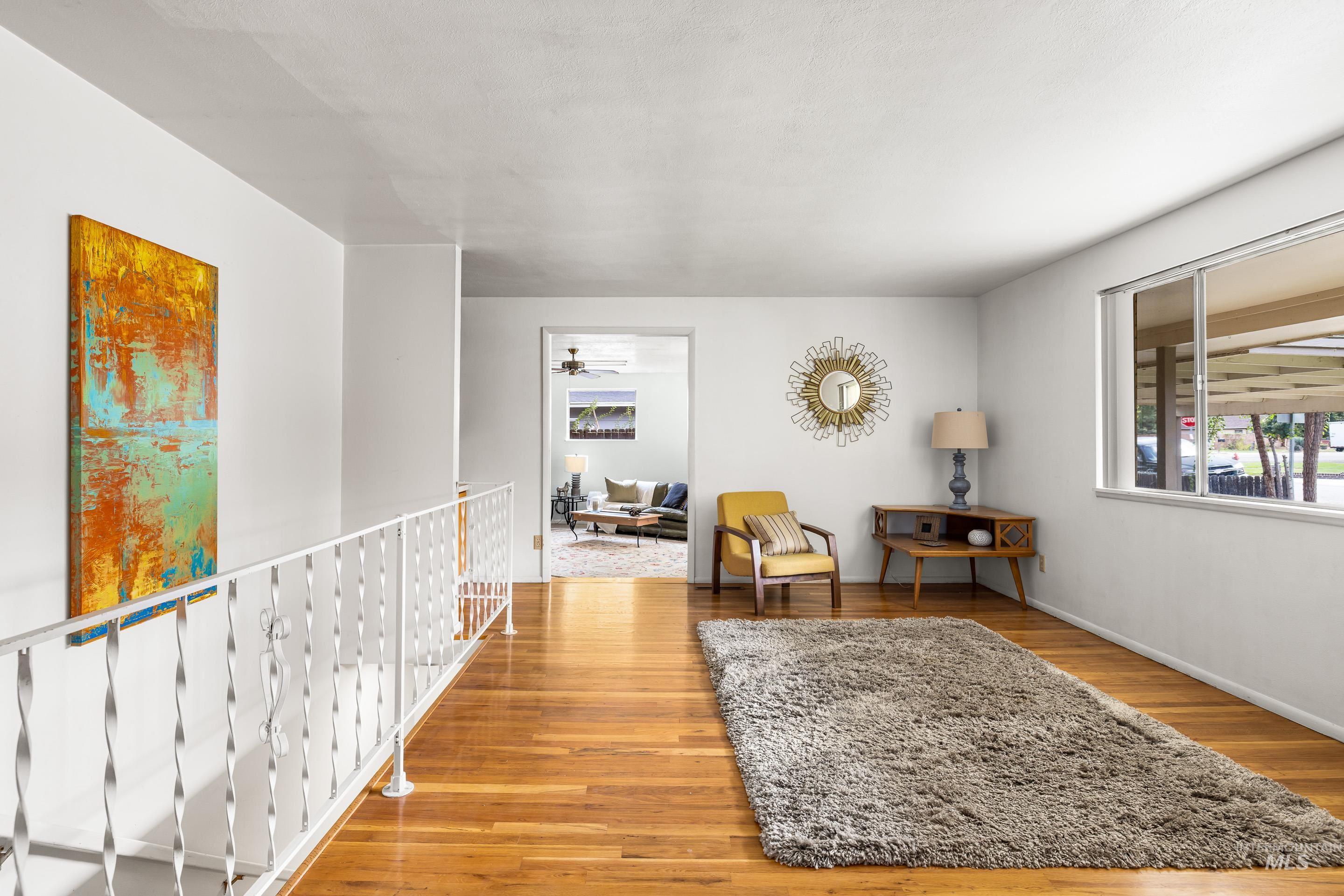Living area with light wood-style floors and ceiling fan