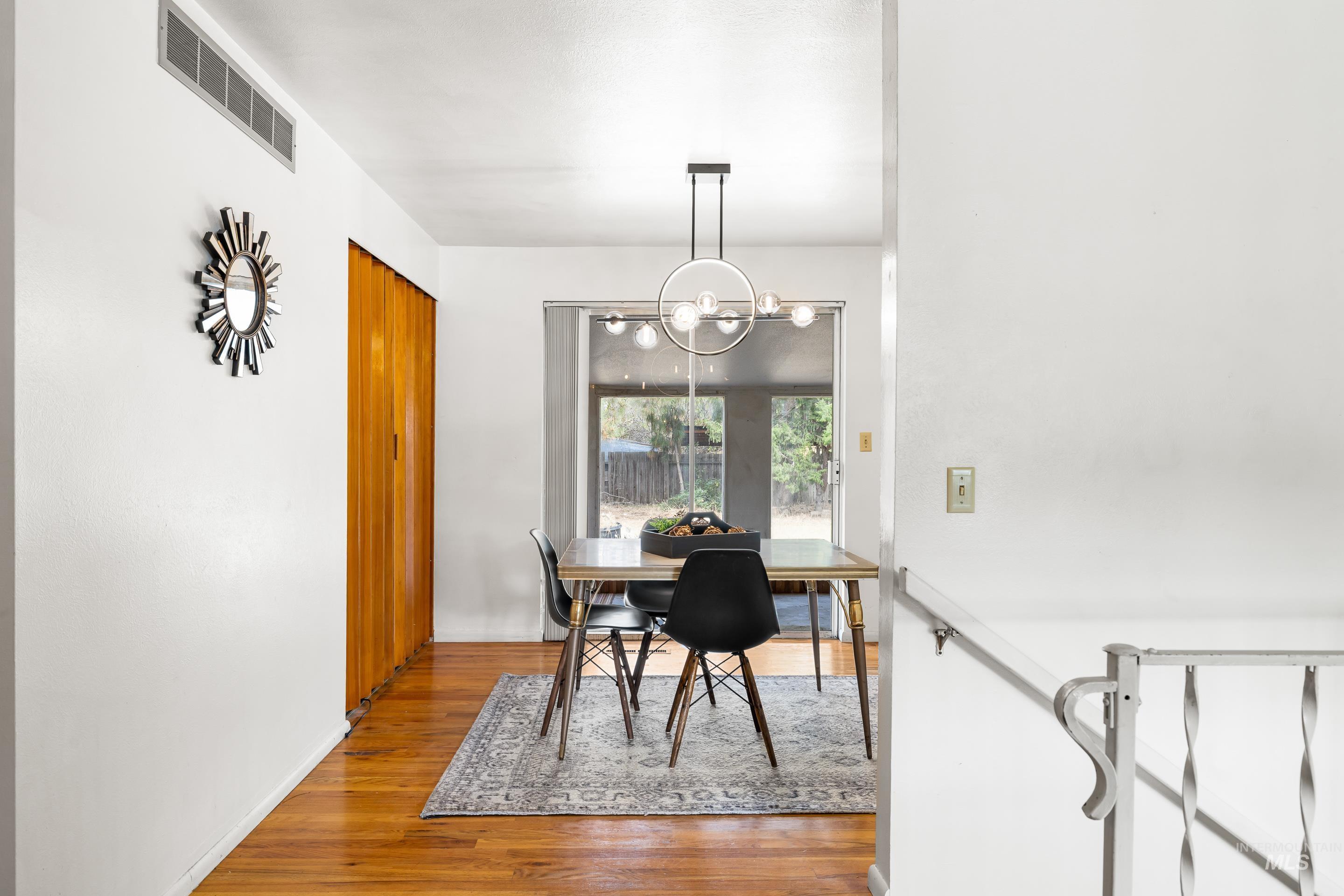 Dining room with wood finished floors and a chandelier