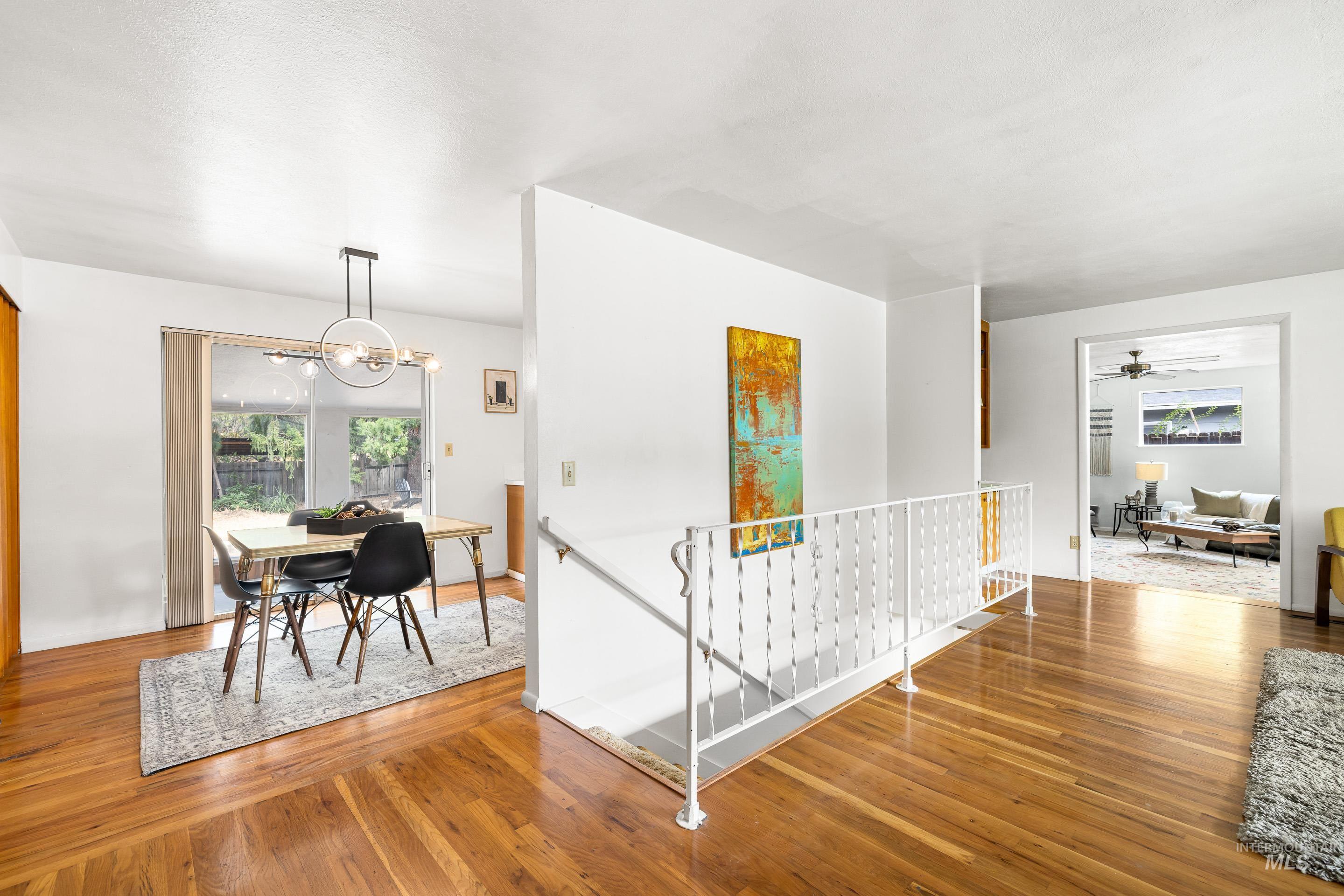 Dining space featuring light wood-type flooring, healthy amount of natural light, and a chandelier