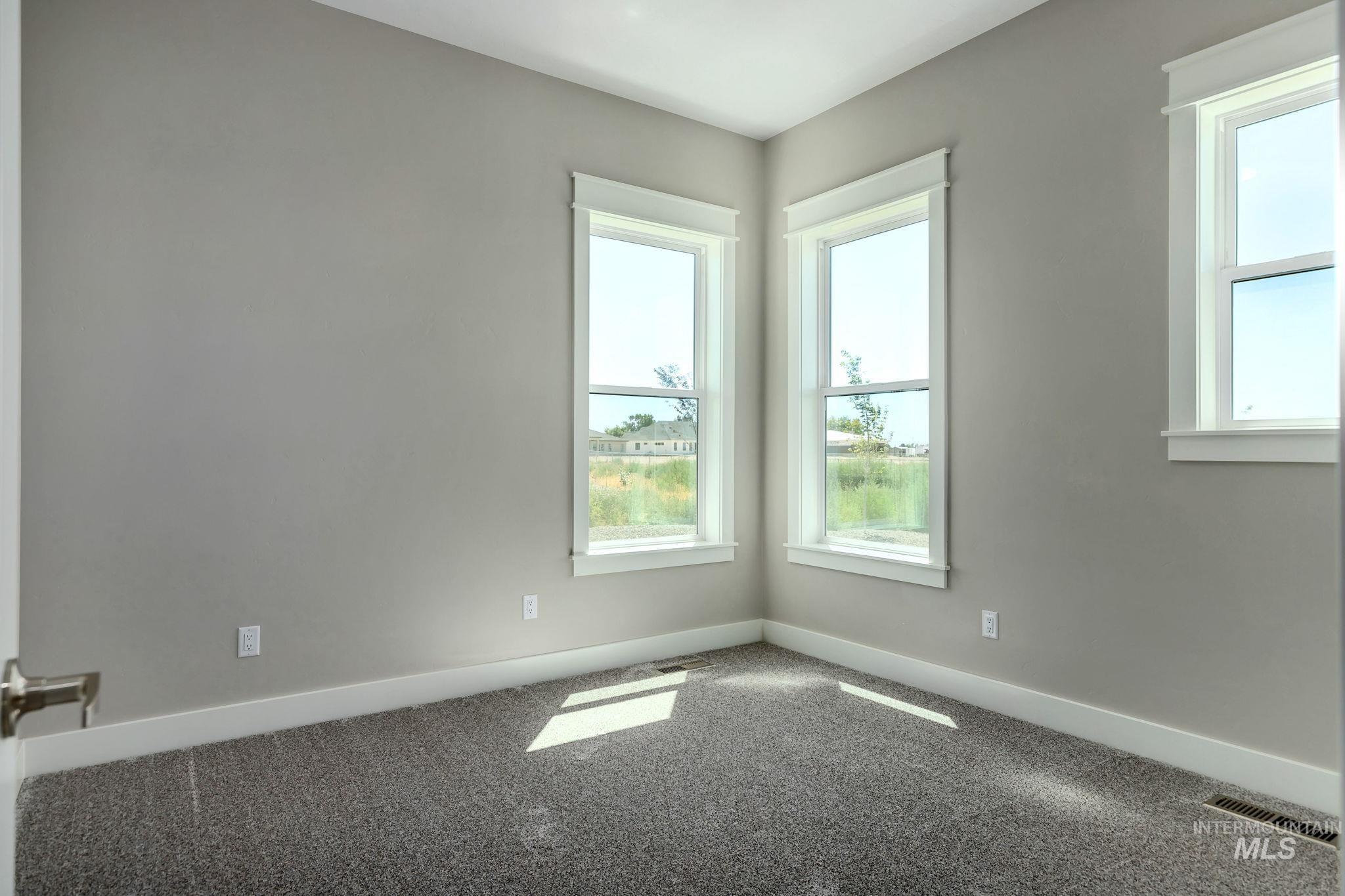 Unfurnished room featuring plenty of natural light and carpet flooring