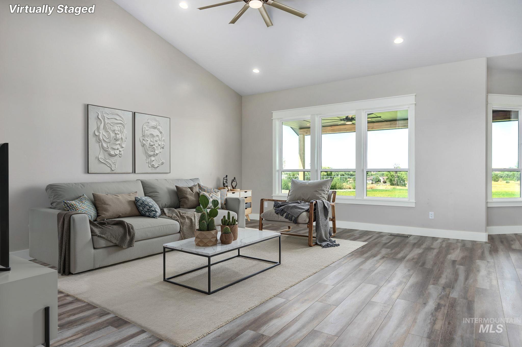 Living room with ceiling fan, wood finished floors, recessed lighting, and high vaulted ceiling