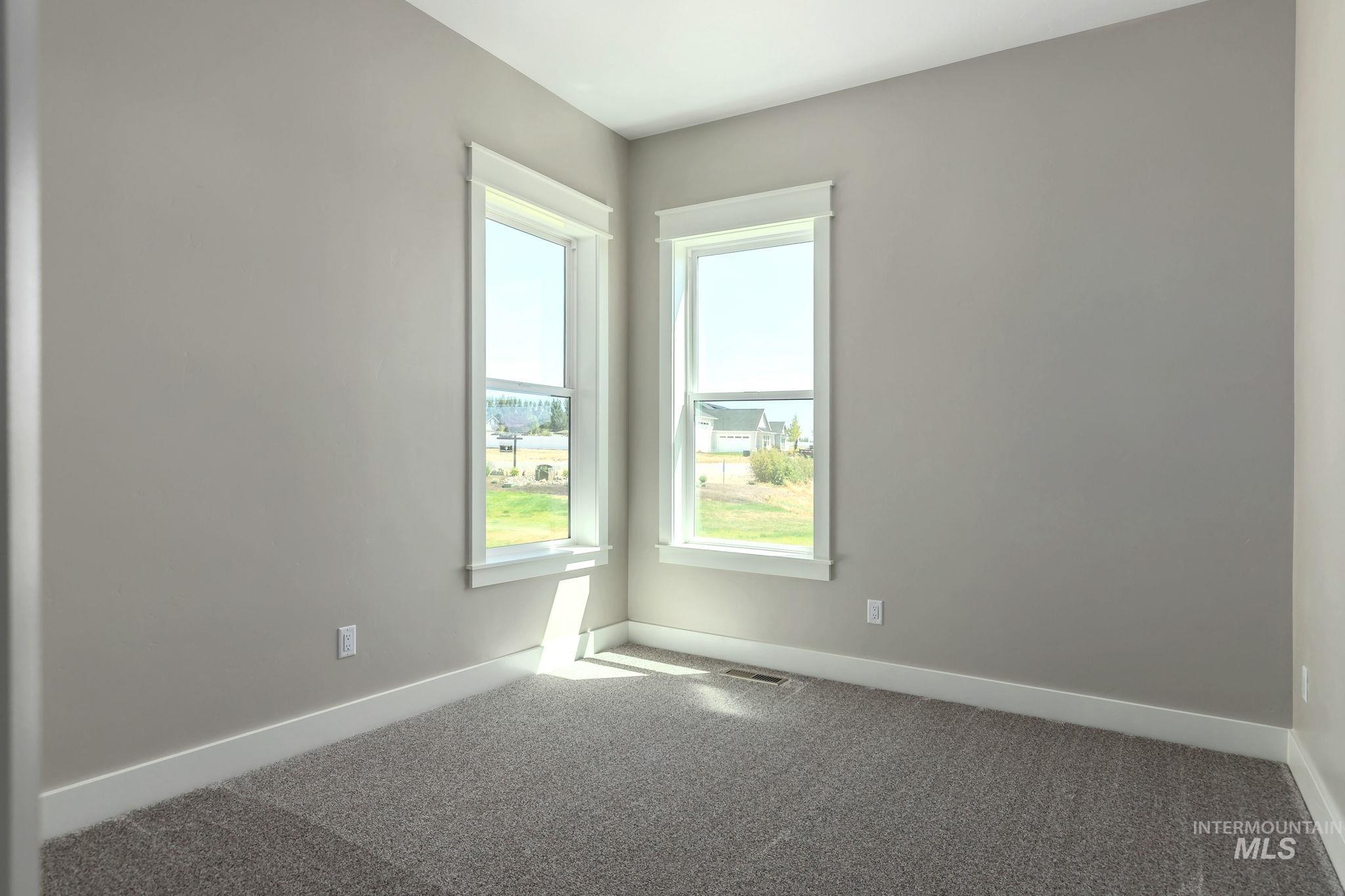 Spare room featuring carpet floors and baseboards