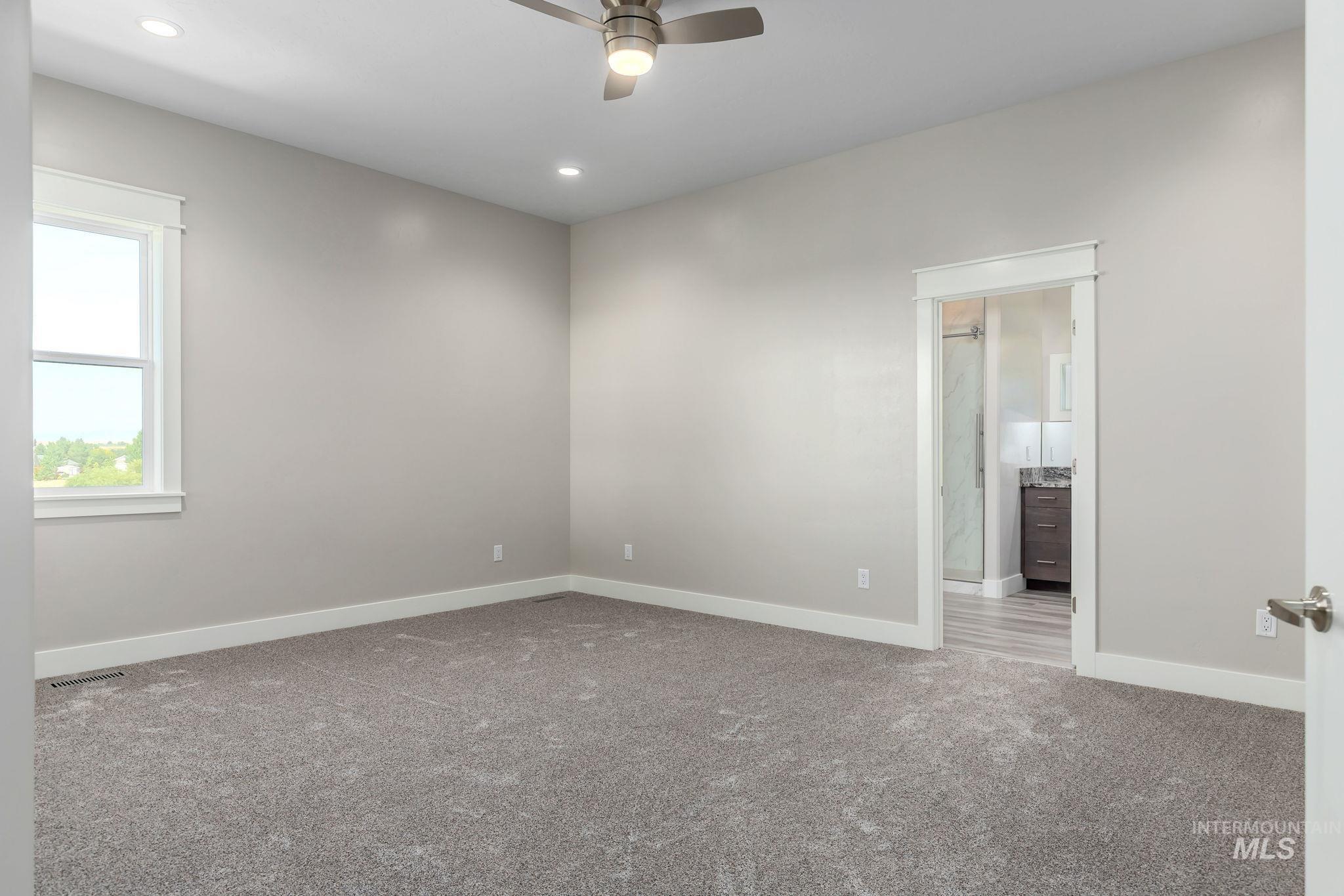 Carpeted empty room featuring a ceiling fan and recessed lighting