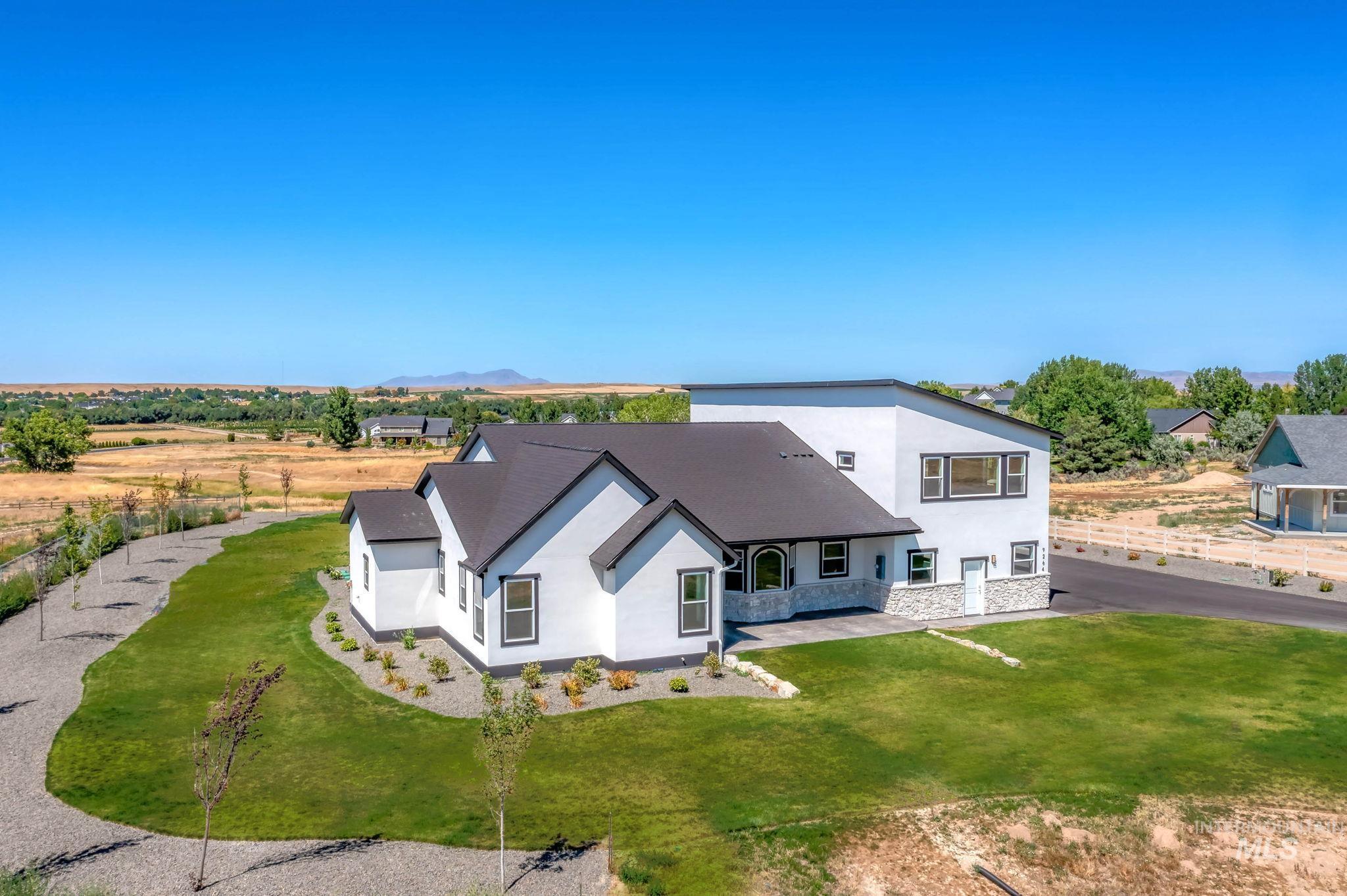 View of front facade featuring stucco siding, stone siding, and a front lawn