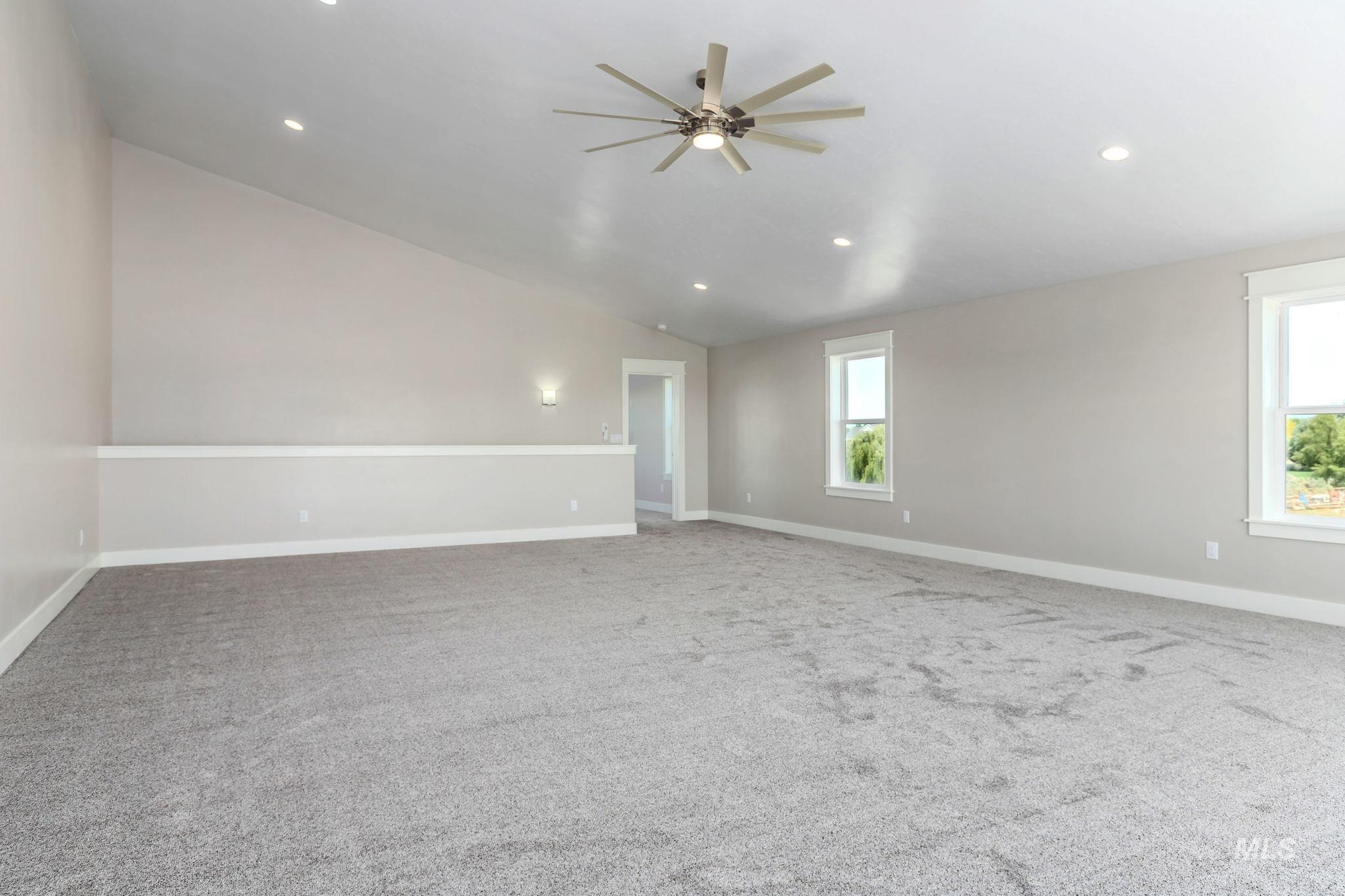 Unfurnished room featuring lofted ceiling, ceiling fan, carpet floors, and recessed lighting