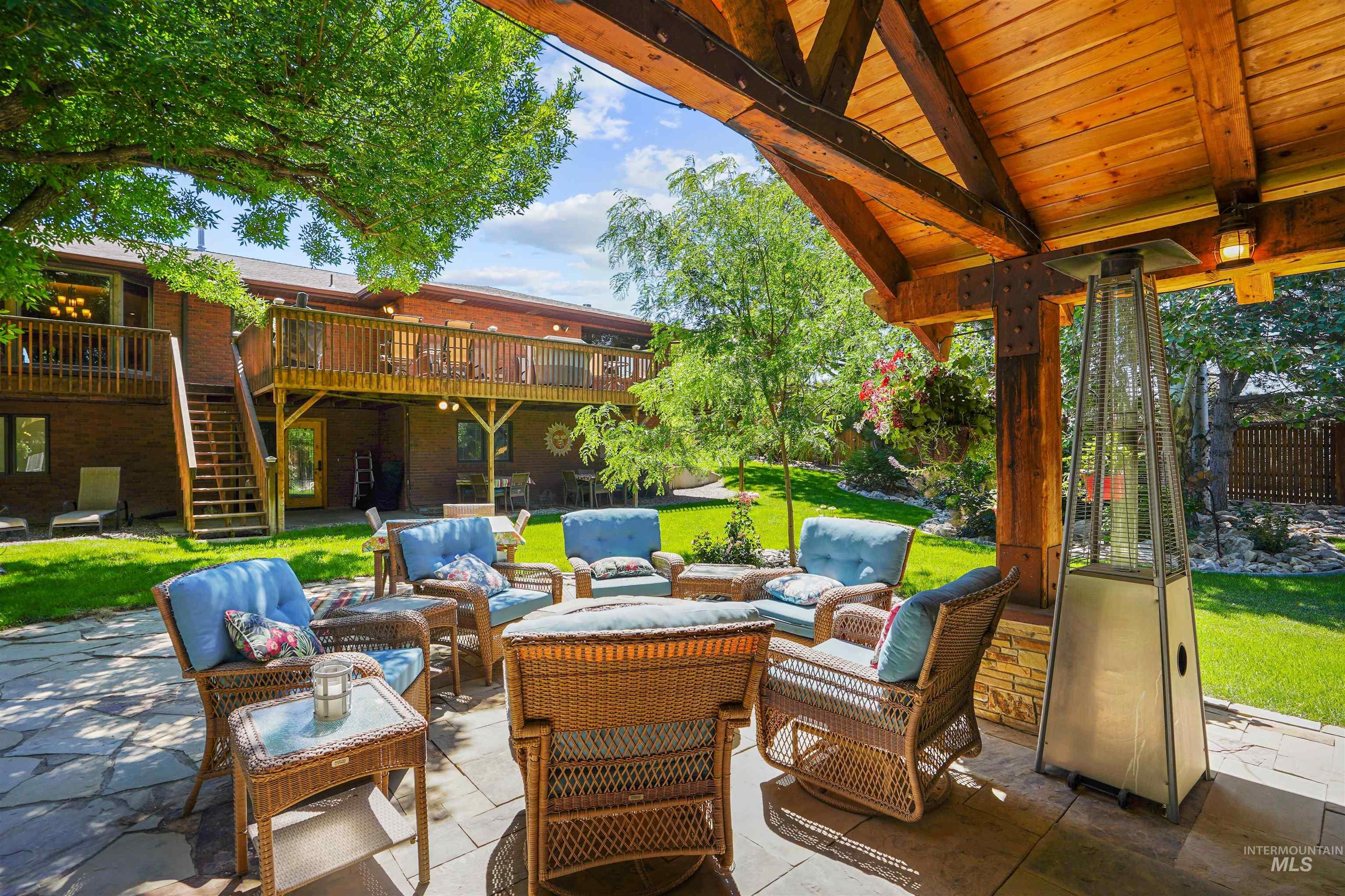 View of patio with an outdoor hangout area, stairway, and a wooden deck