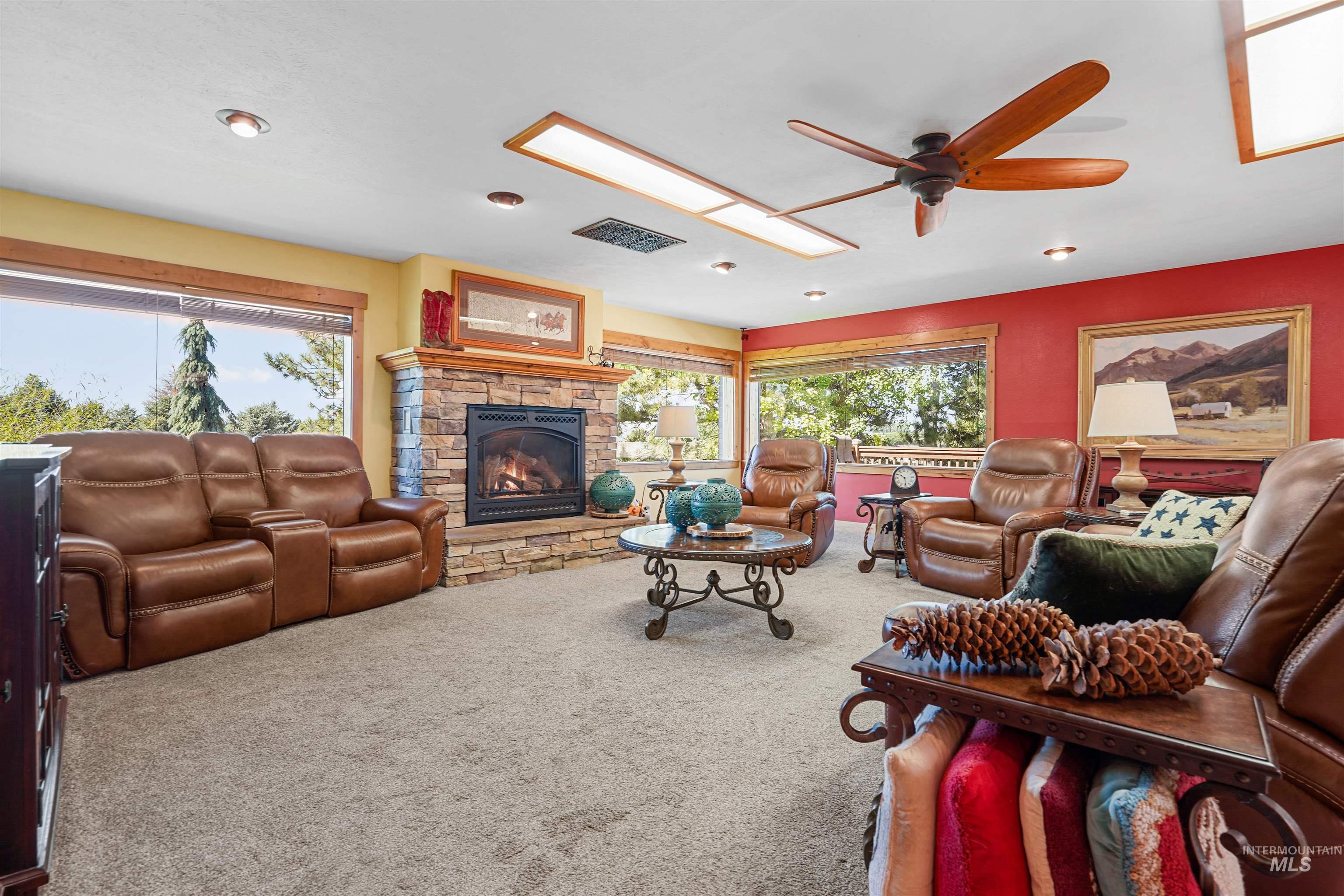 Carpeted living room featuring a ceiling fan, a fireplace, plenty of natural light, and recessed lighting