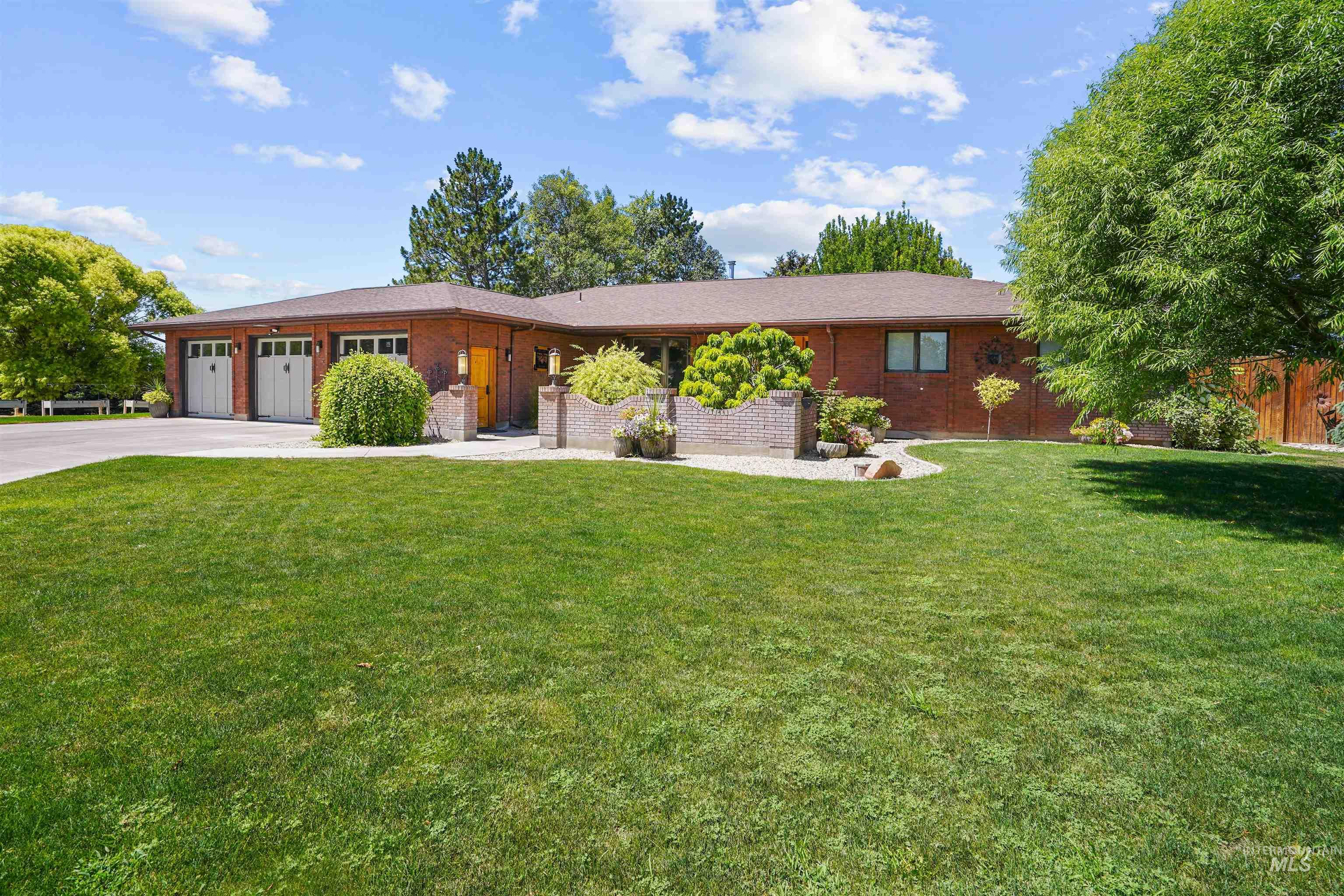 Ranch-style home featuring a garage, concrete driveway, and brick siding