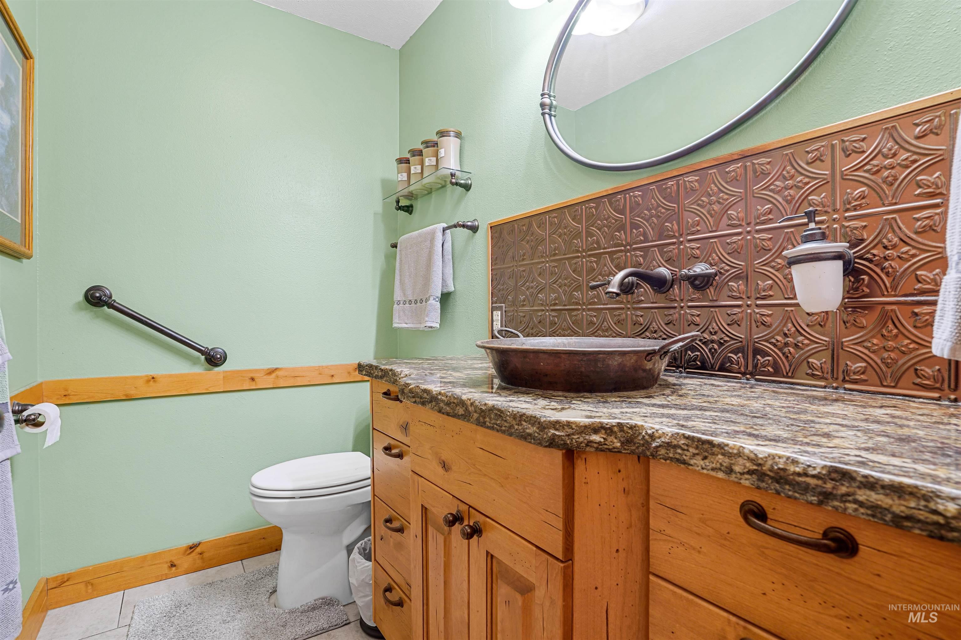Bathroom featuring vanity, tile patterned floors, and tasteful backsplash
