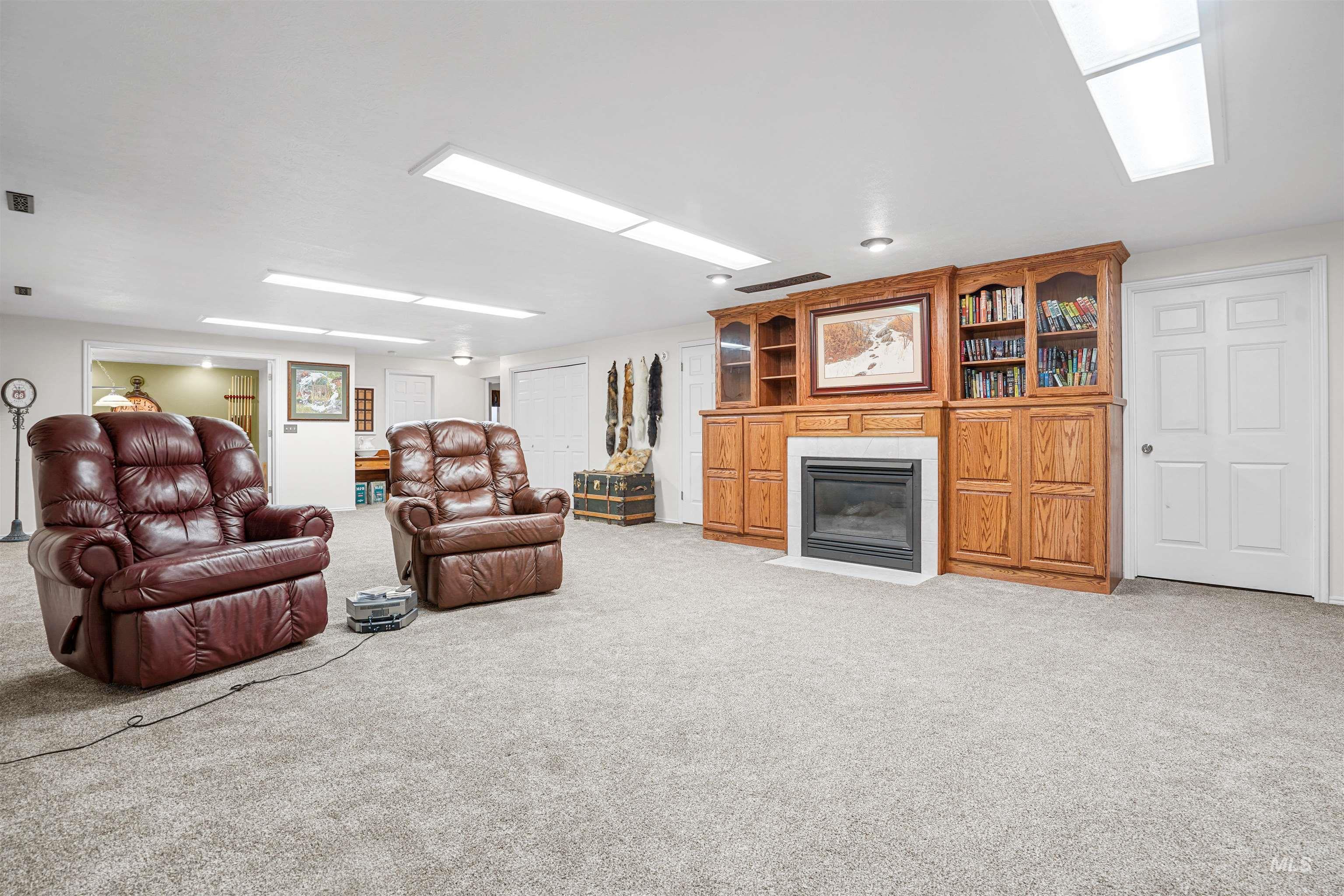 Living area featuring light colored carpet and a fireplace with flush hearth