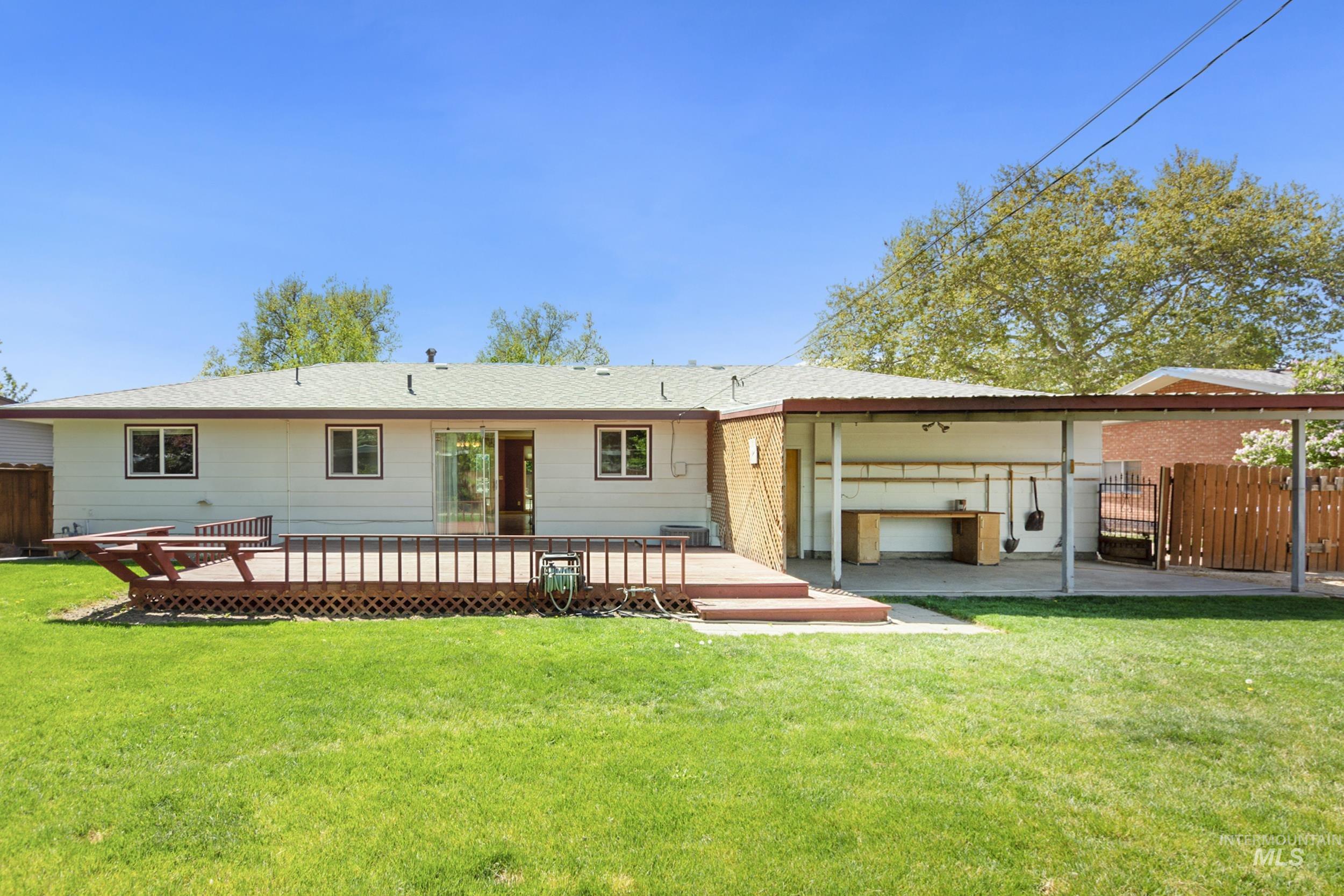 Rear view of house with a wooden deck and a patio area