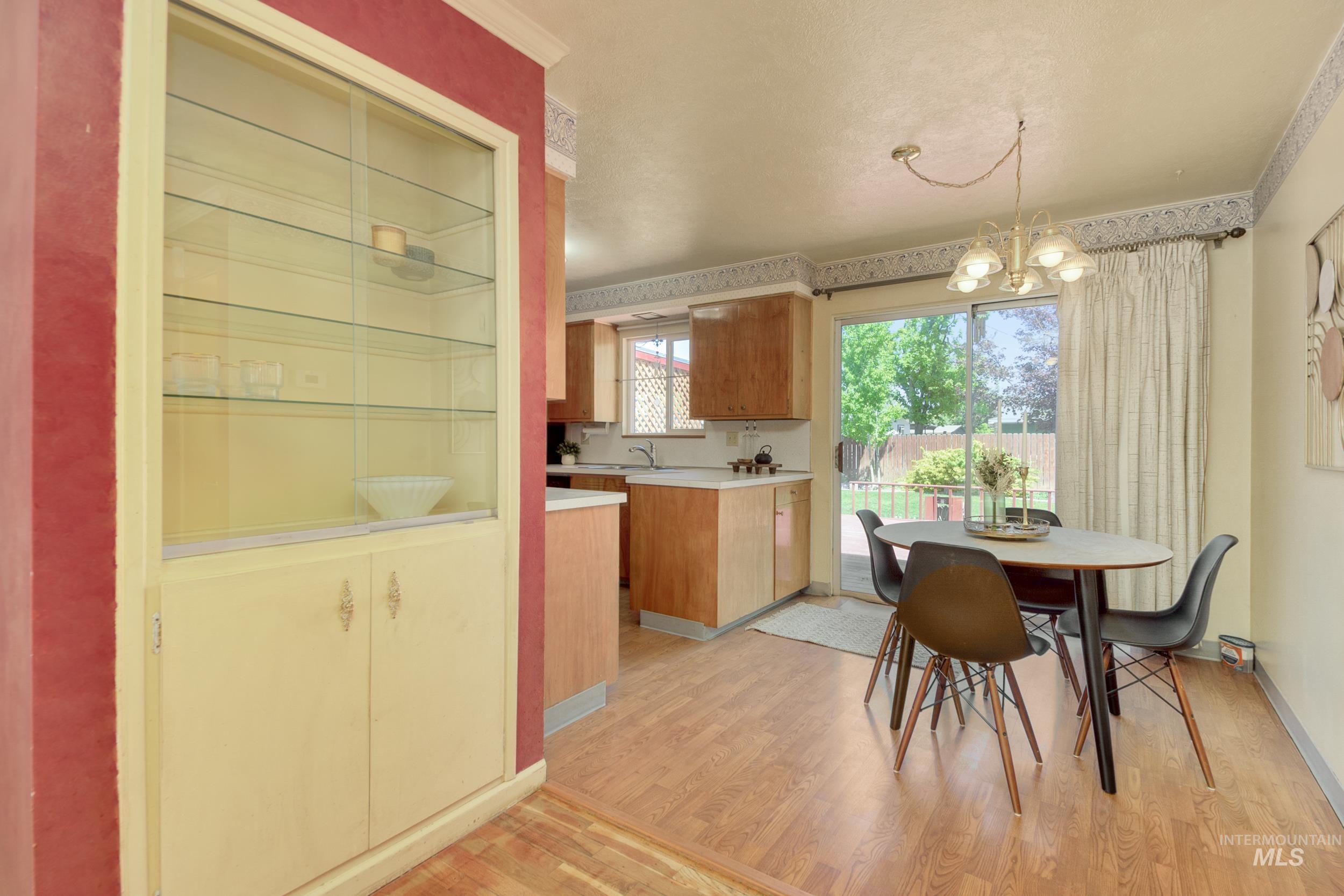 Dining space with light wood-style floors and a chandelier