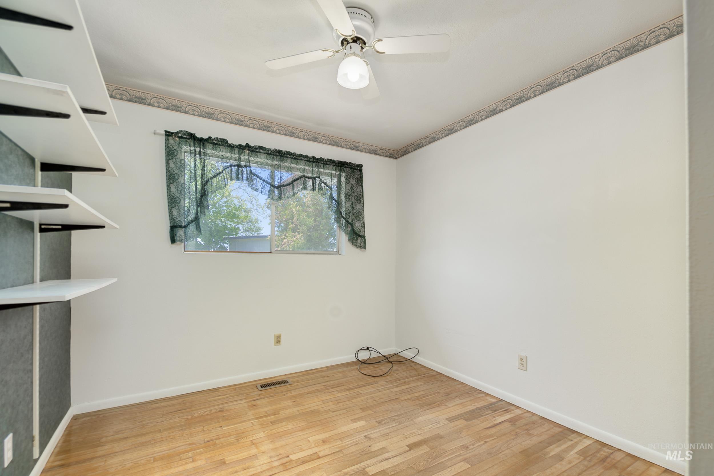 Spare room featuring light wood-style floors and a ceiling fan