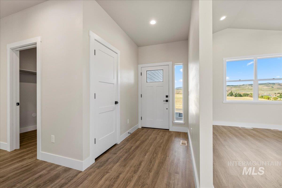 Entrance foyer featuring wood finished floors, vaulted ceiling, and recessed lighting
