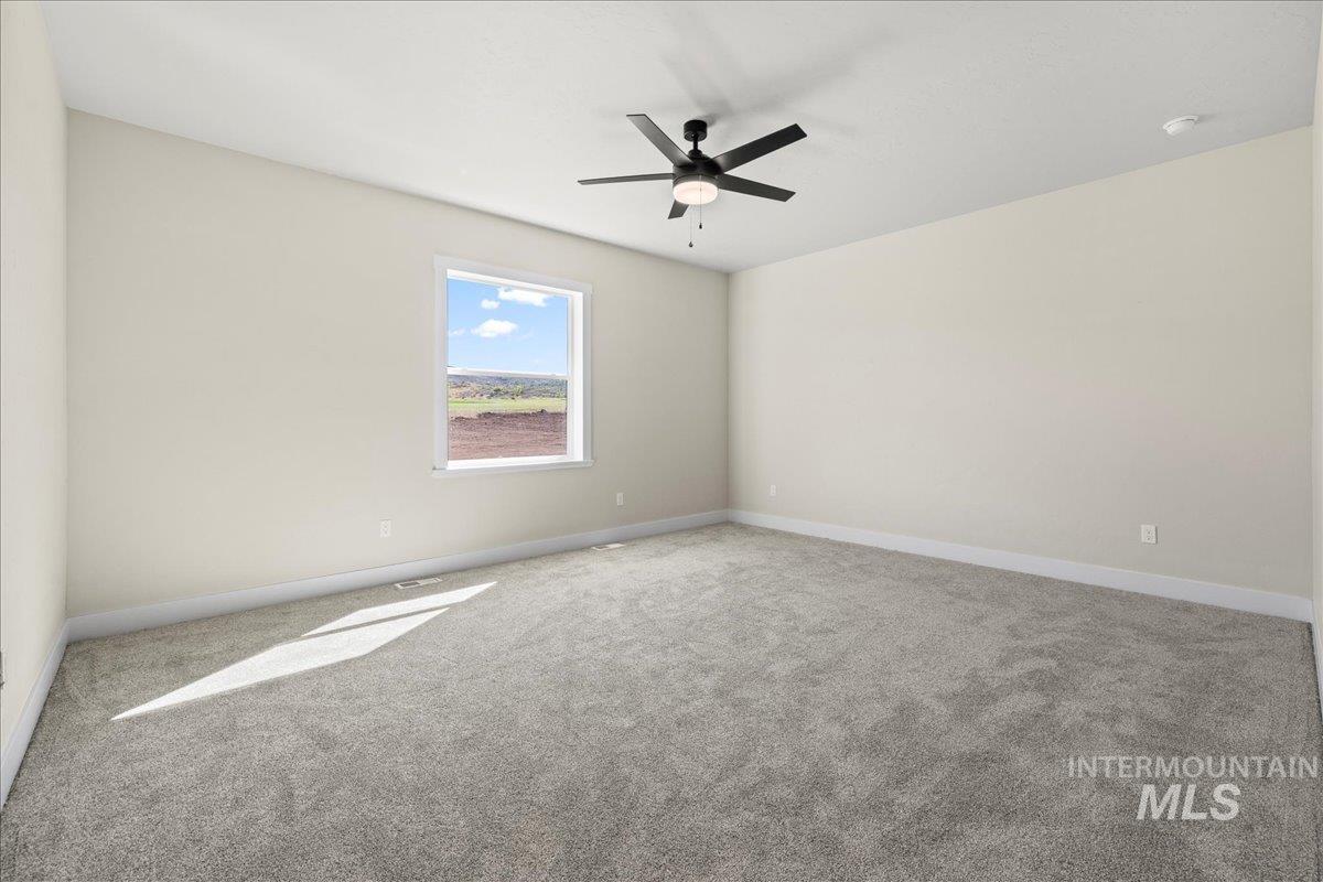Spare room featuring carpet flooring and ceiling fan