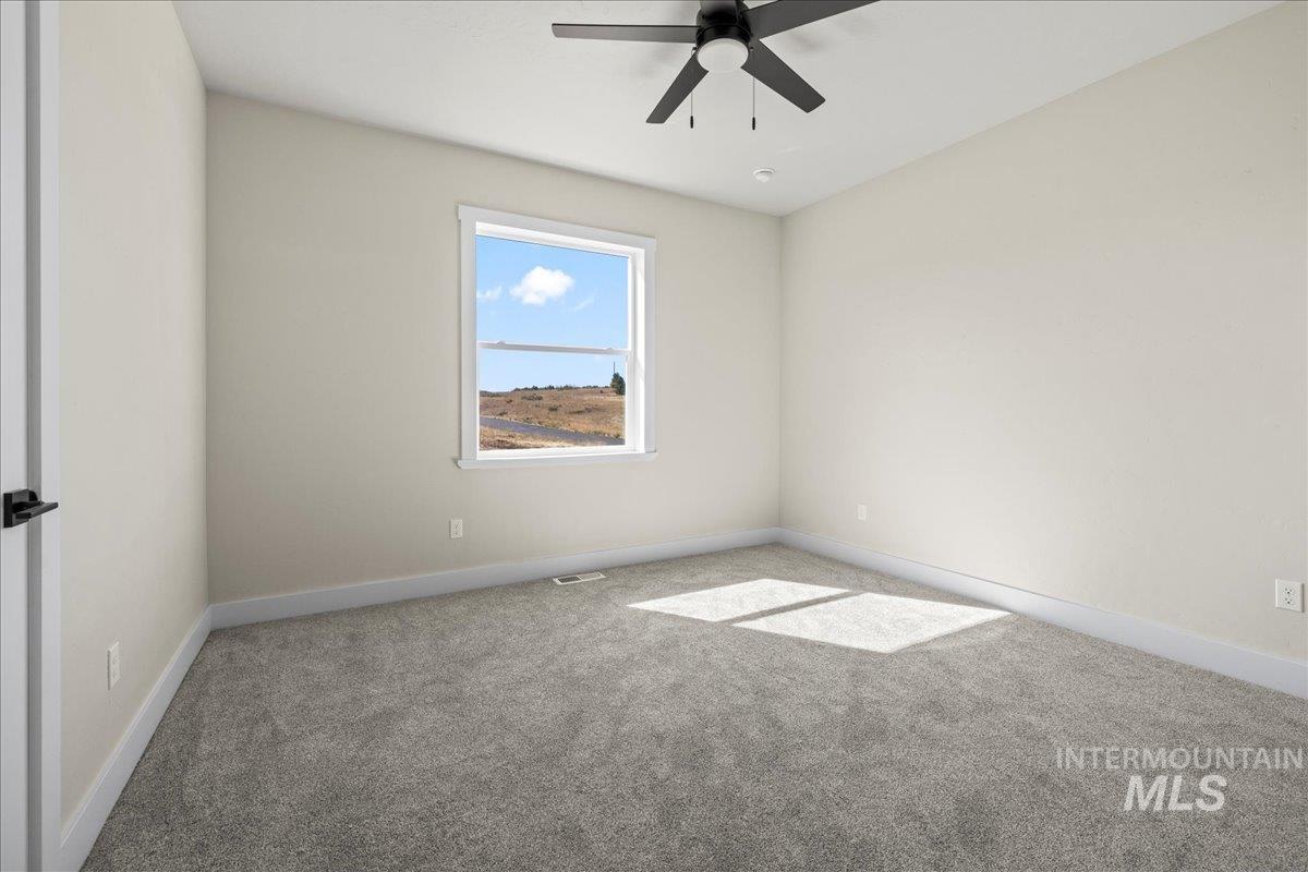 Empty room with carpet flooring and ceiling fan