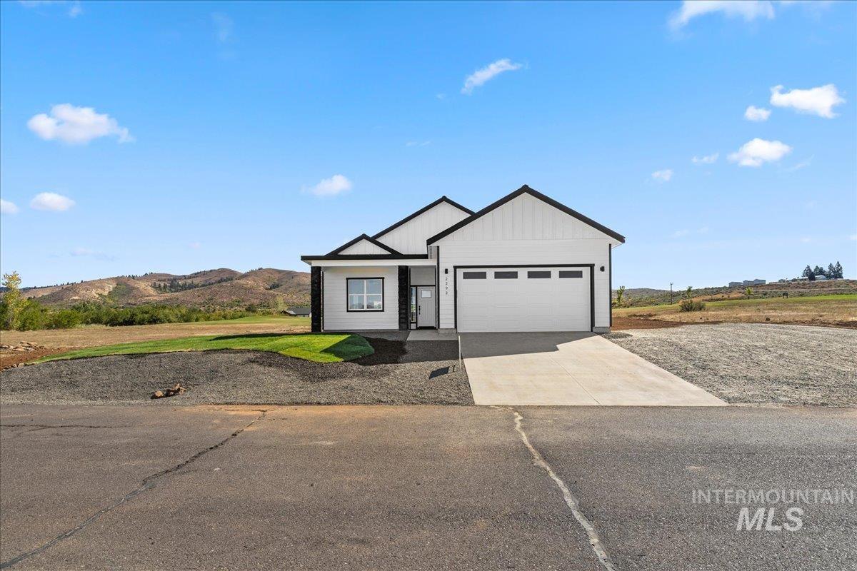 View of front facade with concrete driveway, an attached garage, and a mountain view