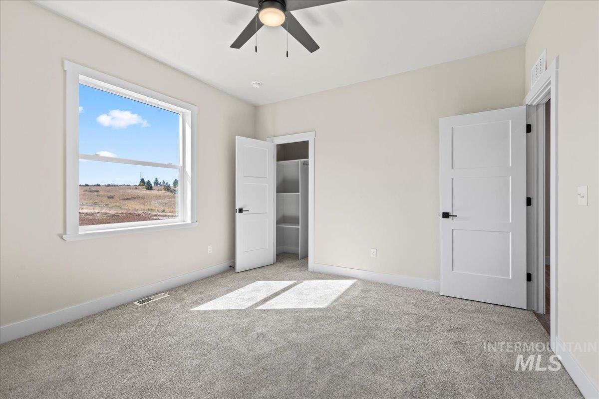 Unfurnished bedroom with light carpet, a ceiling fan, and a closet