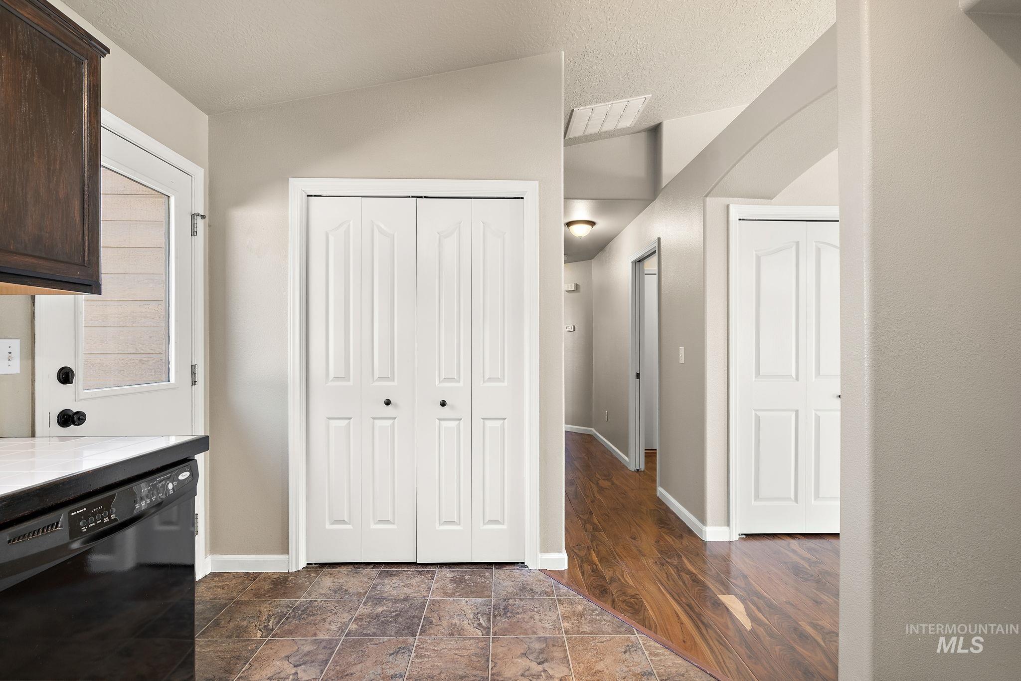 Kitchen with dishwasher, tile counters, a textured ceiling, and dark brown cabinetry
