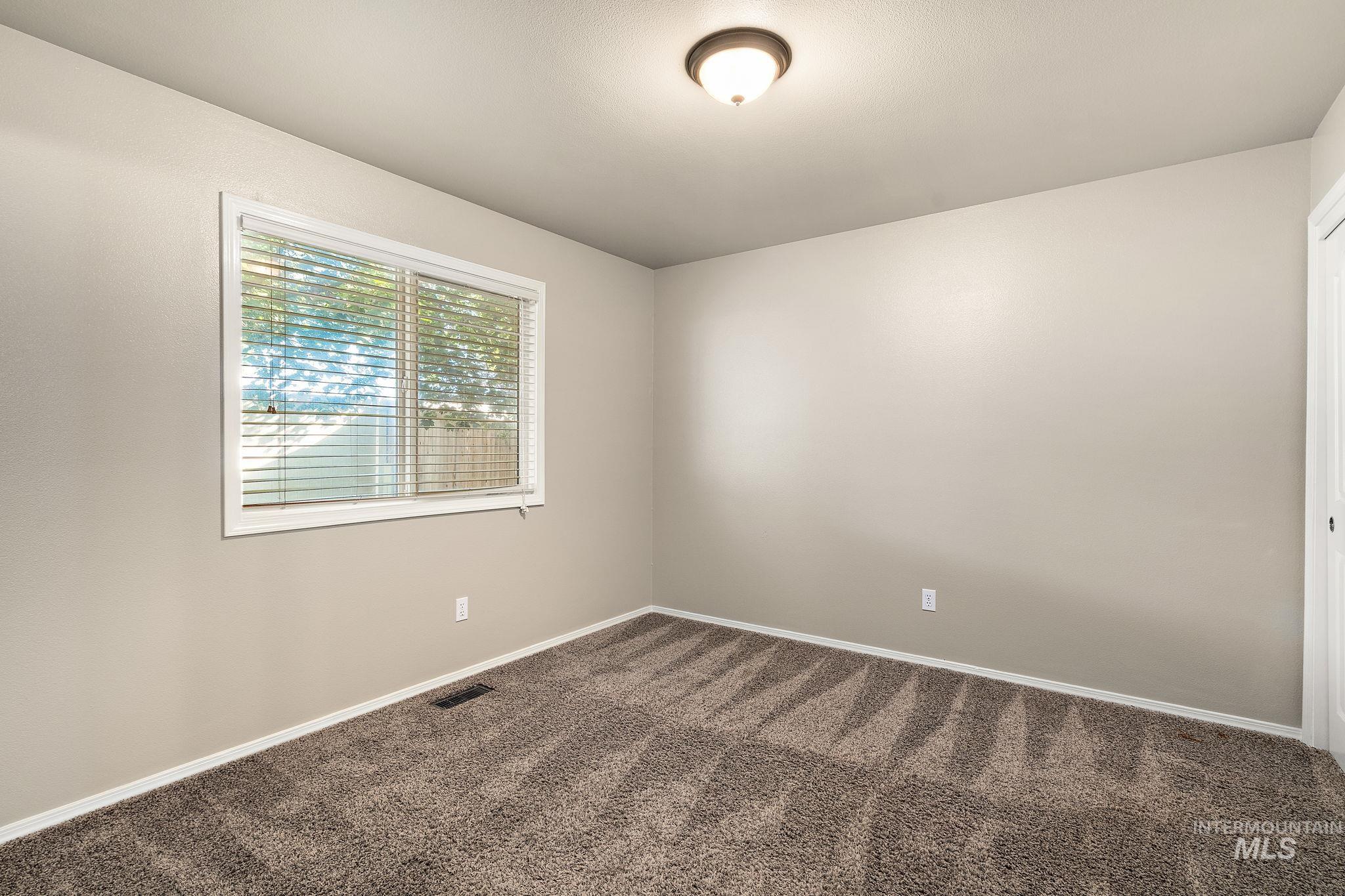 Unfurnished room with carpet and baseboards