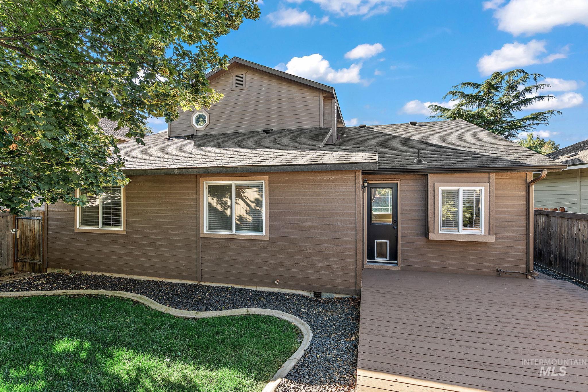 Rear view of house with a shingled roof and a deck