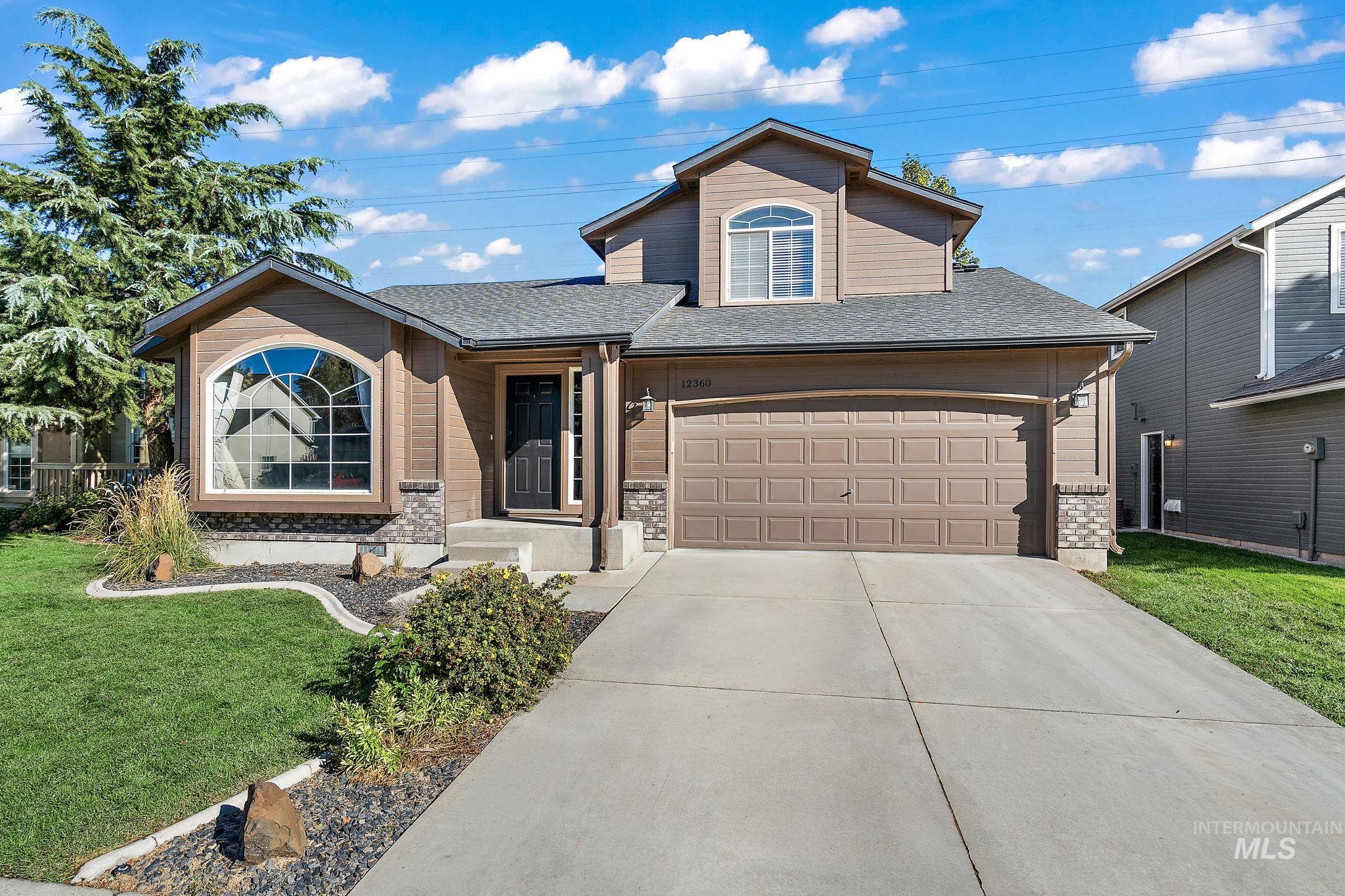 Traditional-style home with roof with shingles, a front yard, and concrete driveway